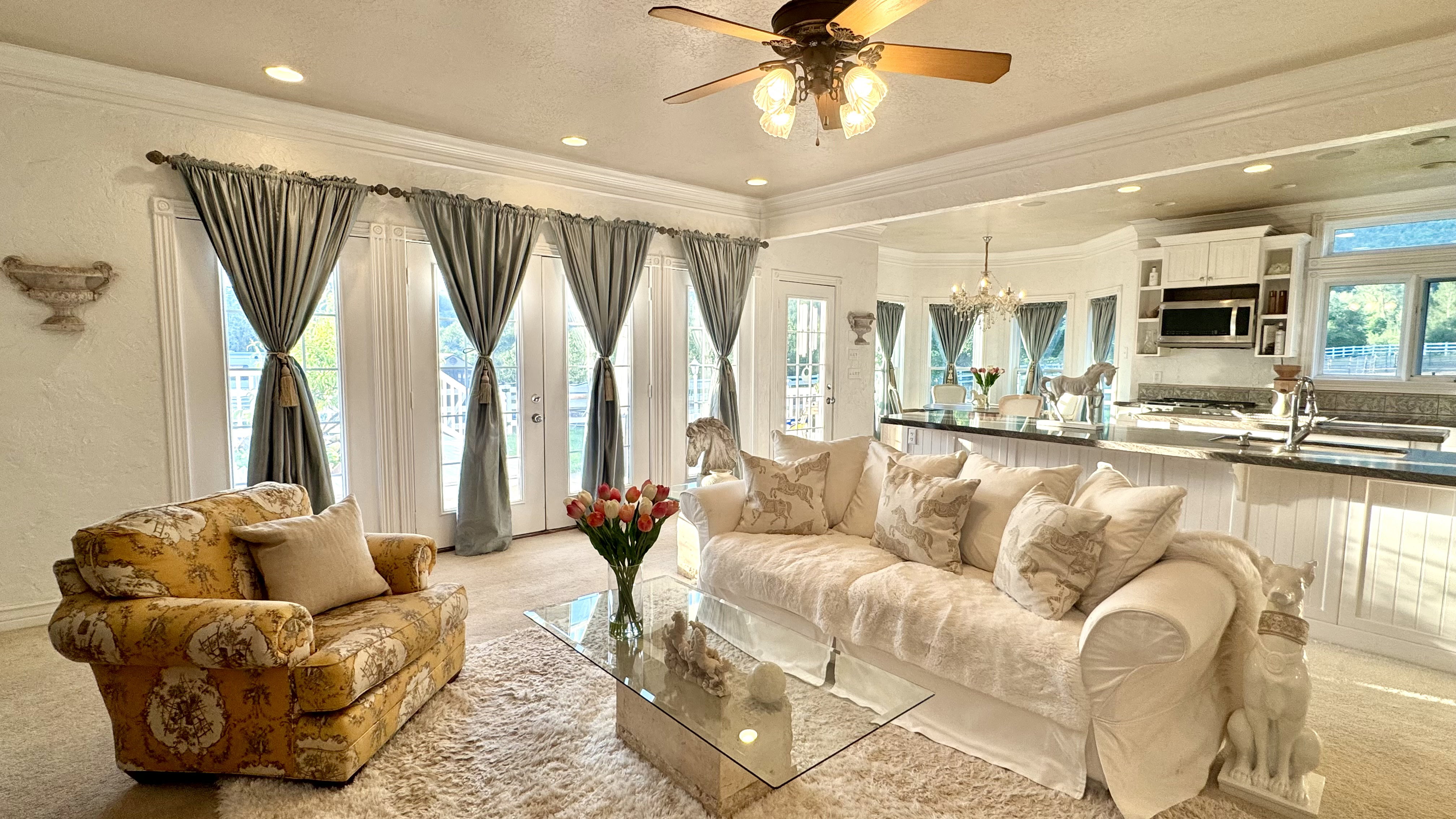 Open-concept living space featuring multiple French doors, recessed lighting, and a ceiling fan