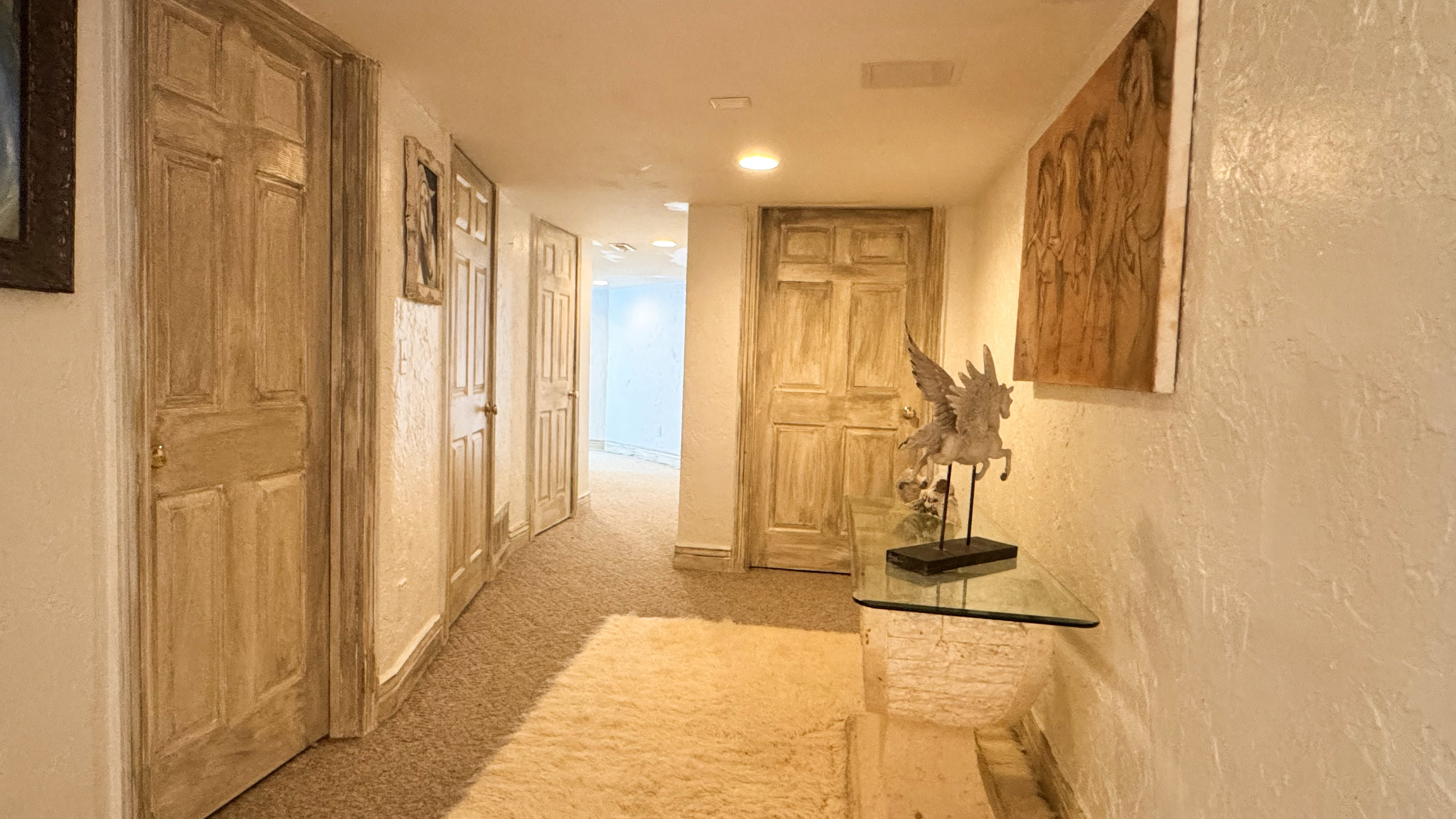 Hallway featuring textured walls, recessed lighting, and carpet flooring