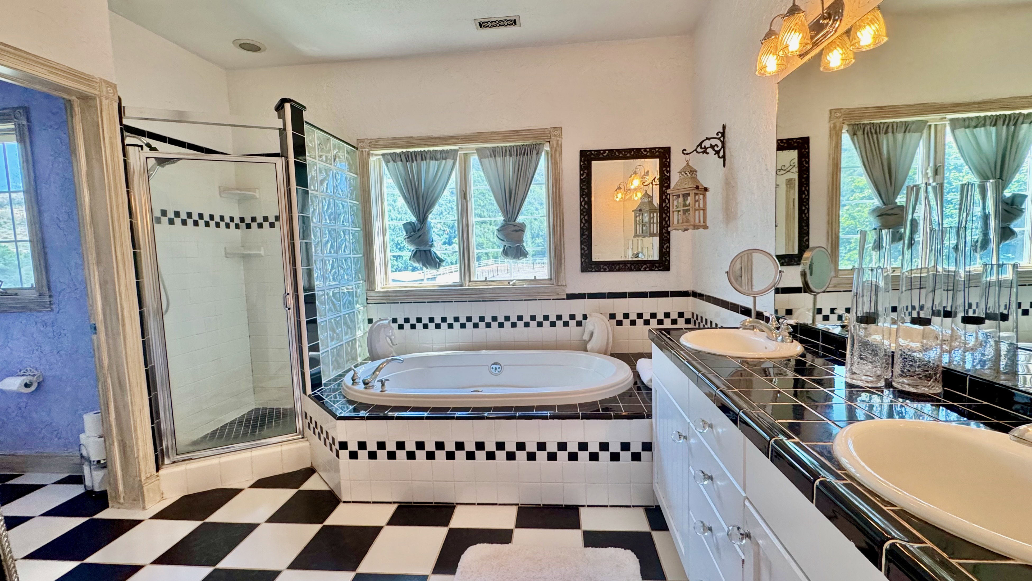 Spacious bathroom featuring a dual vanity, inset soaking tub, and walk-in shower