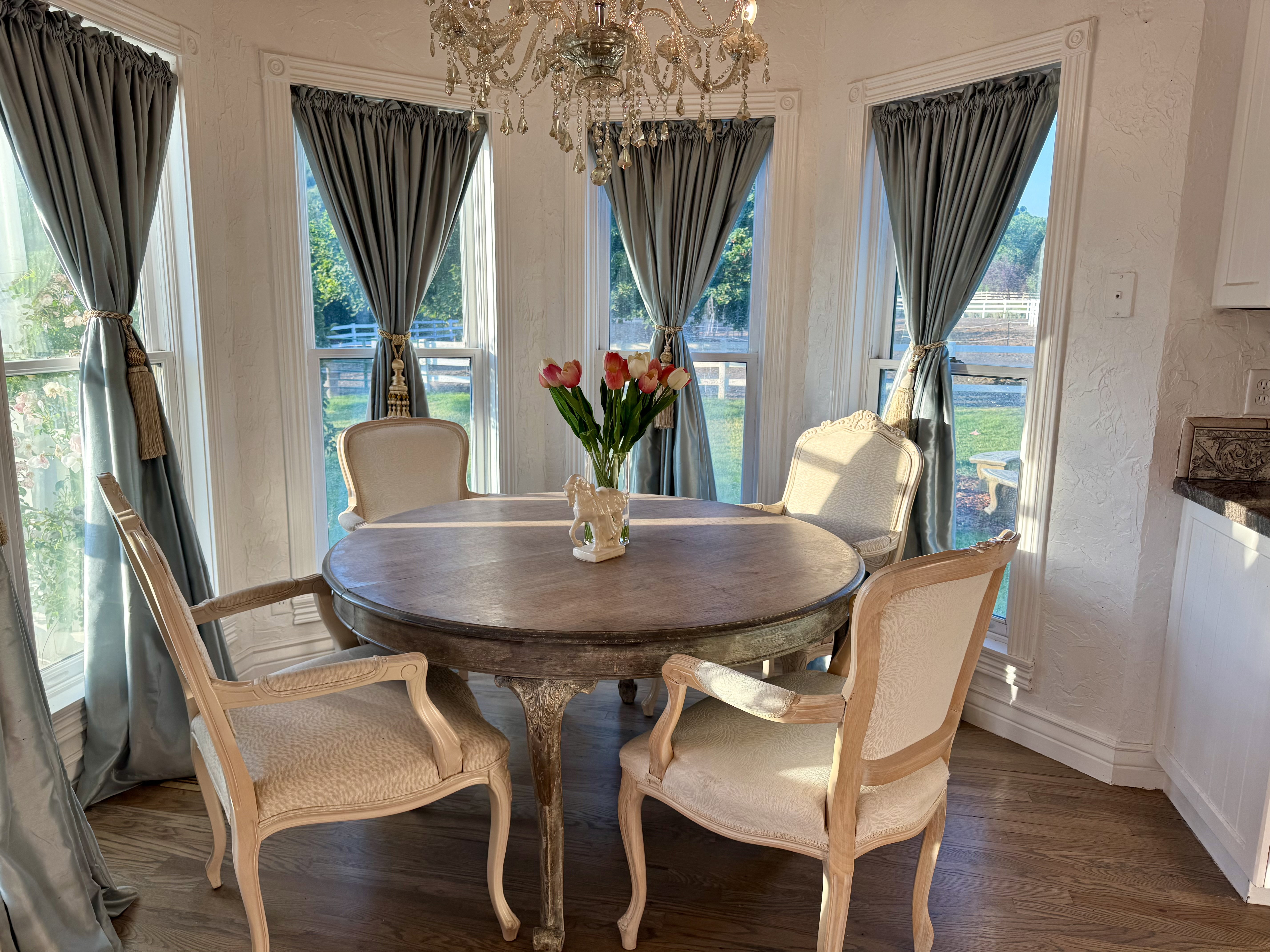 Bay window dining area featuring wood-finish flooring