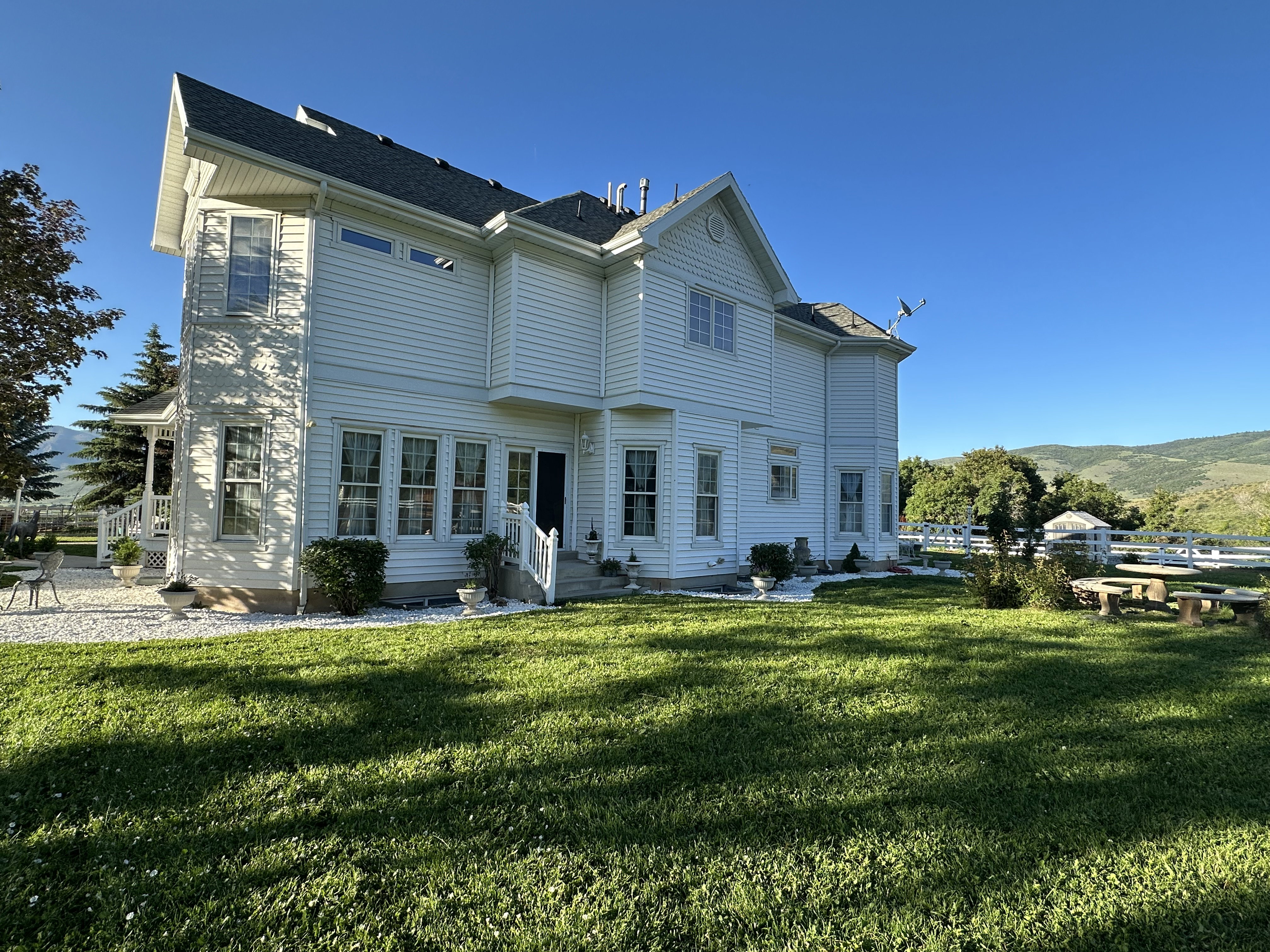 Expansive rear facade featuring white siding and a multi-level roofline