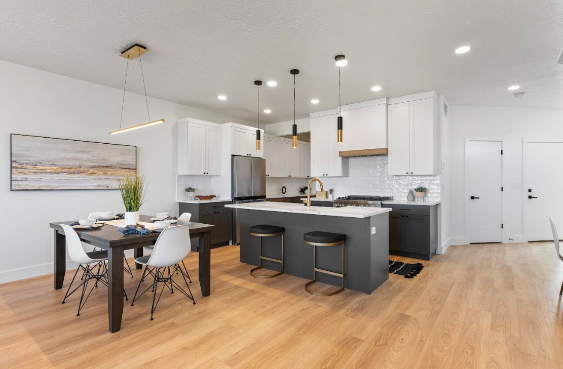 Contemporary kitchen and dining area featuring light wood-finish flooring