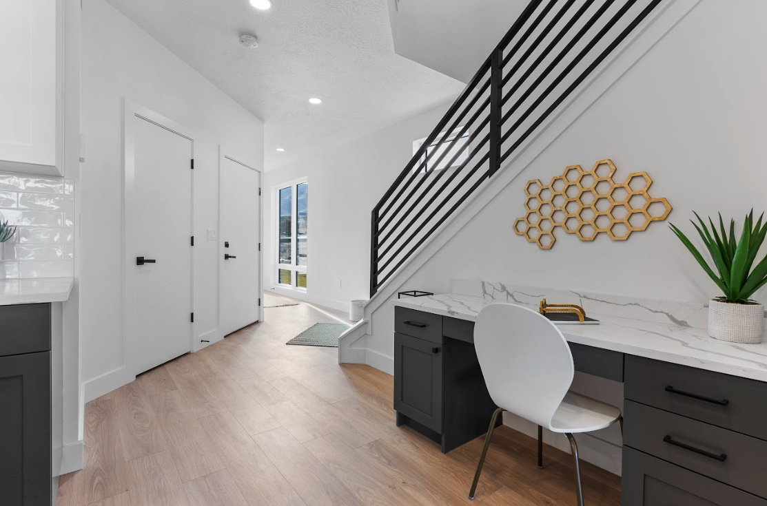 Integrated desk area with a marble-look countertop and dark cabinetry