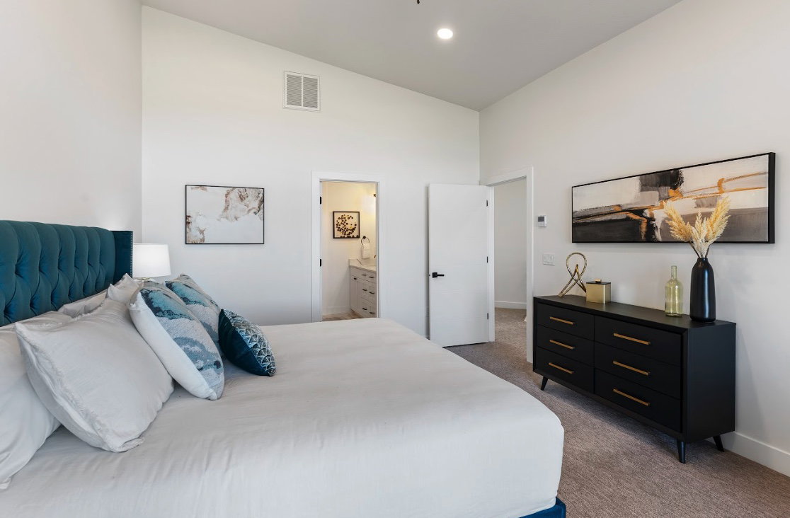 Carpeted bedroom featuring white walls and a vaulted ceiling
