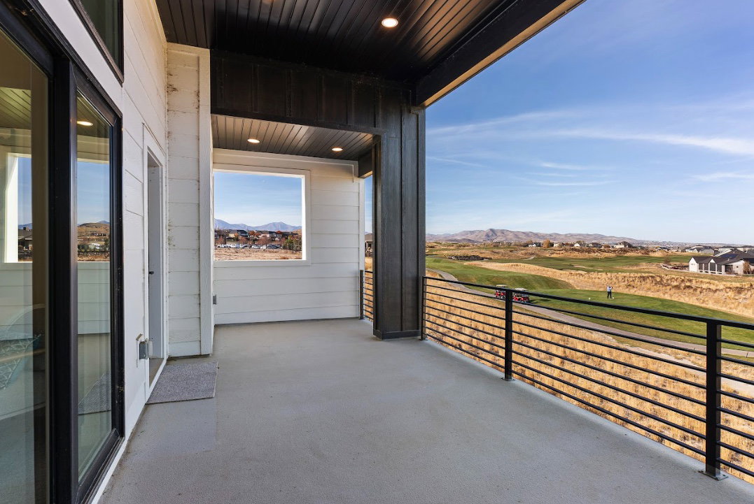 Spacious balcony featuring concrete flooring, a horizontal bar railing, and a dark wood-finish ceiling with recessed lighting