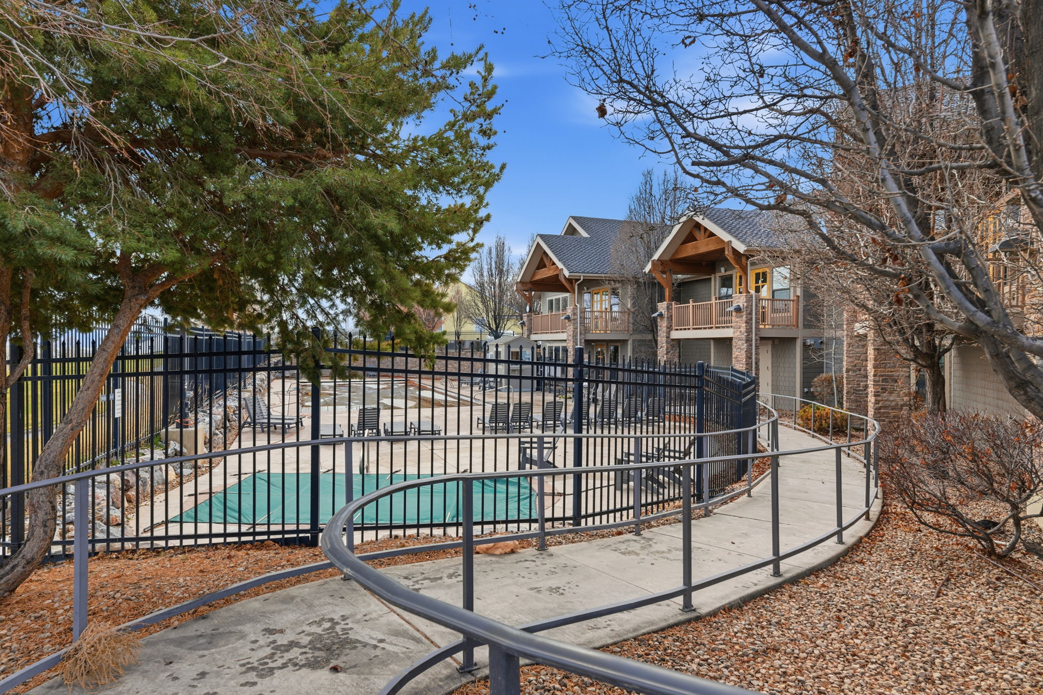 Outdoor pool area featuring a perimeter fence and covered pool