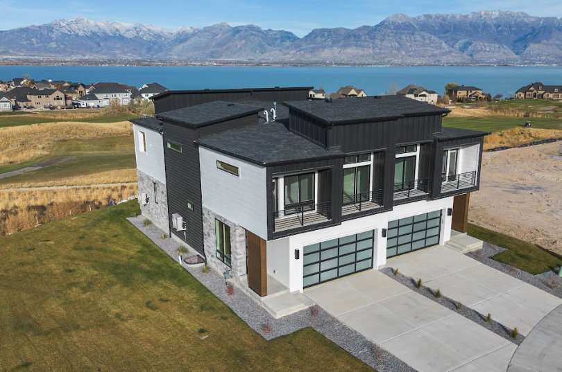 Modern exterior featuring a dark gray roof, vertical dark siding, light gray siding, and stone accents