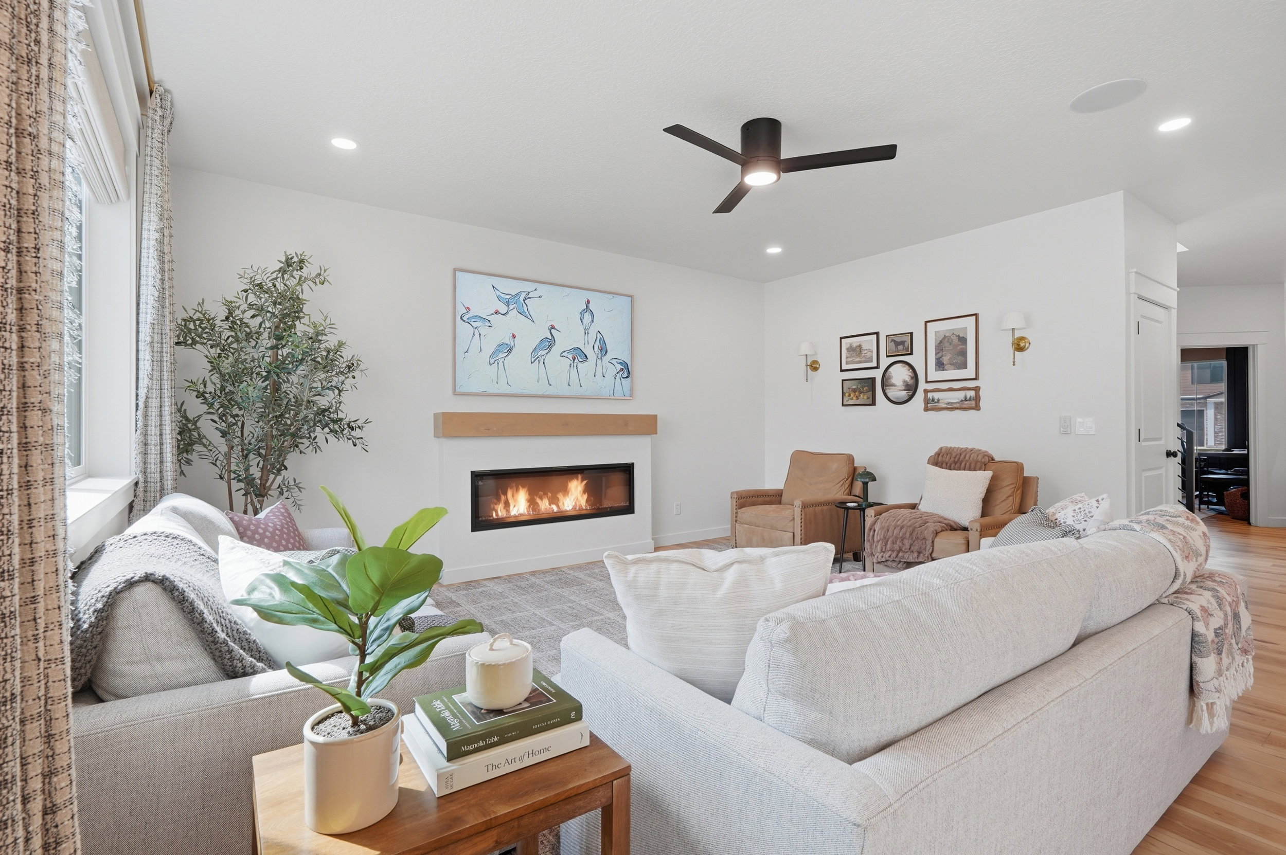 Contemporary living space featuring a linear fireplace with a wood mantle, recessed lighting, and a ceiling fan