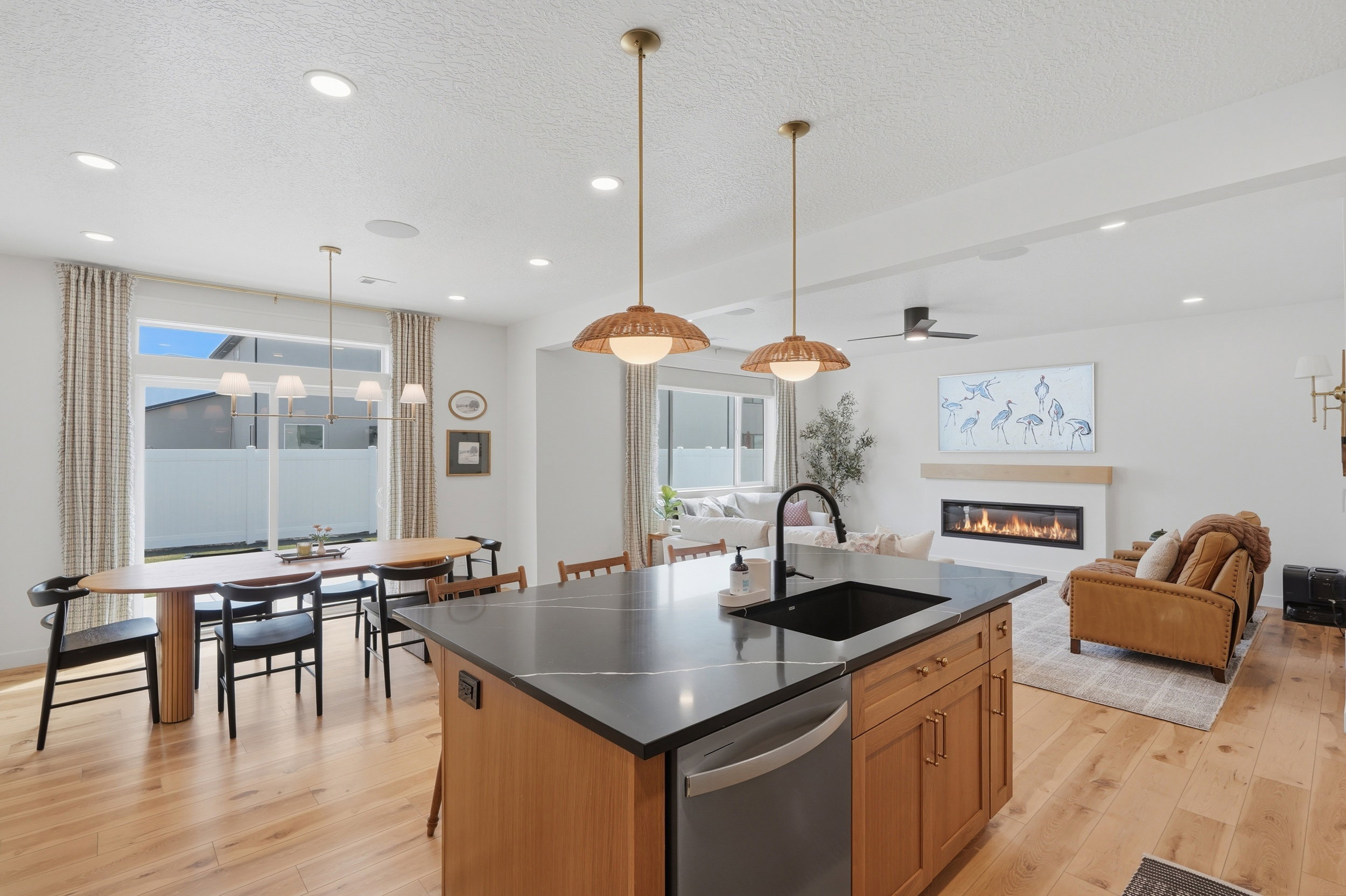 Kitchen island with dark countertop, integrated sink, and dishwasher