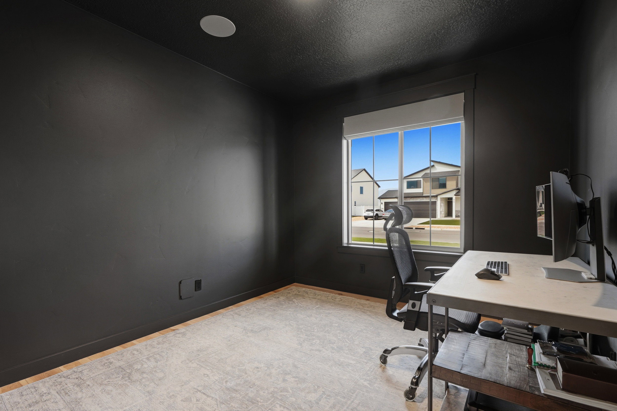 Room featuring dark-painted walls and light wood-finish flooring