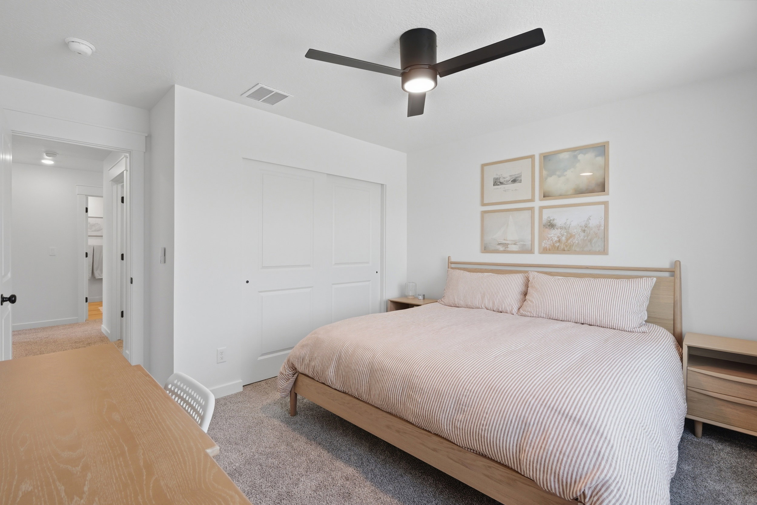 Bedroom featuring a ceiling fan with integrated lighting, textured carpet flooring, and a built-in closet with sliding panel doors