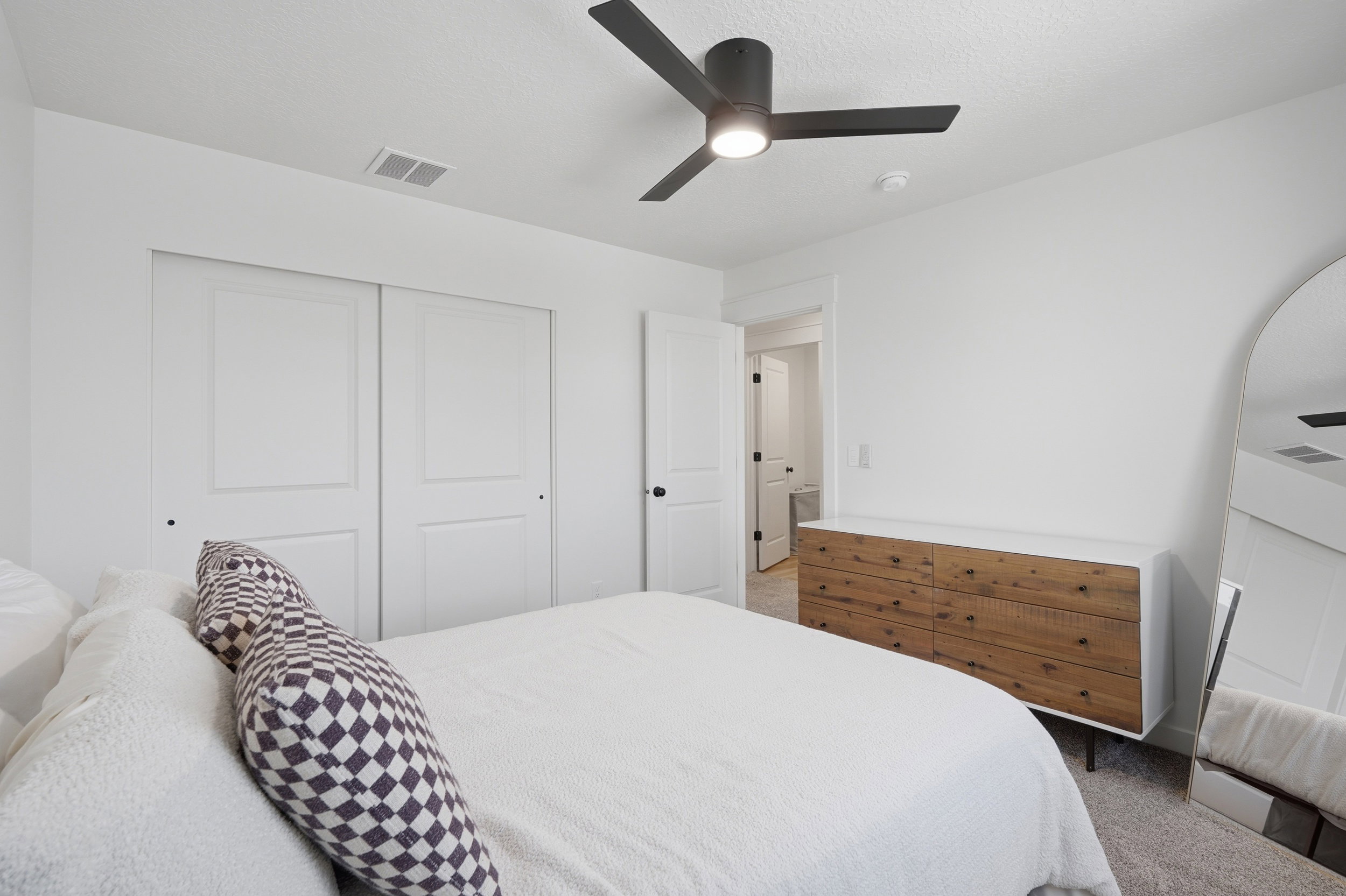 White walls complement the dark ceiling fan with integrated lighting