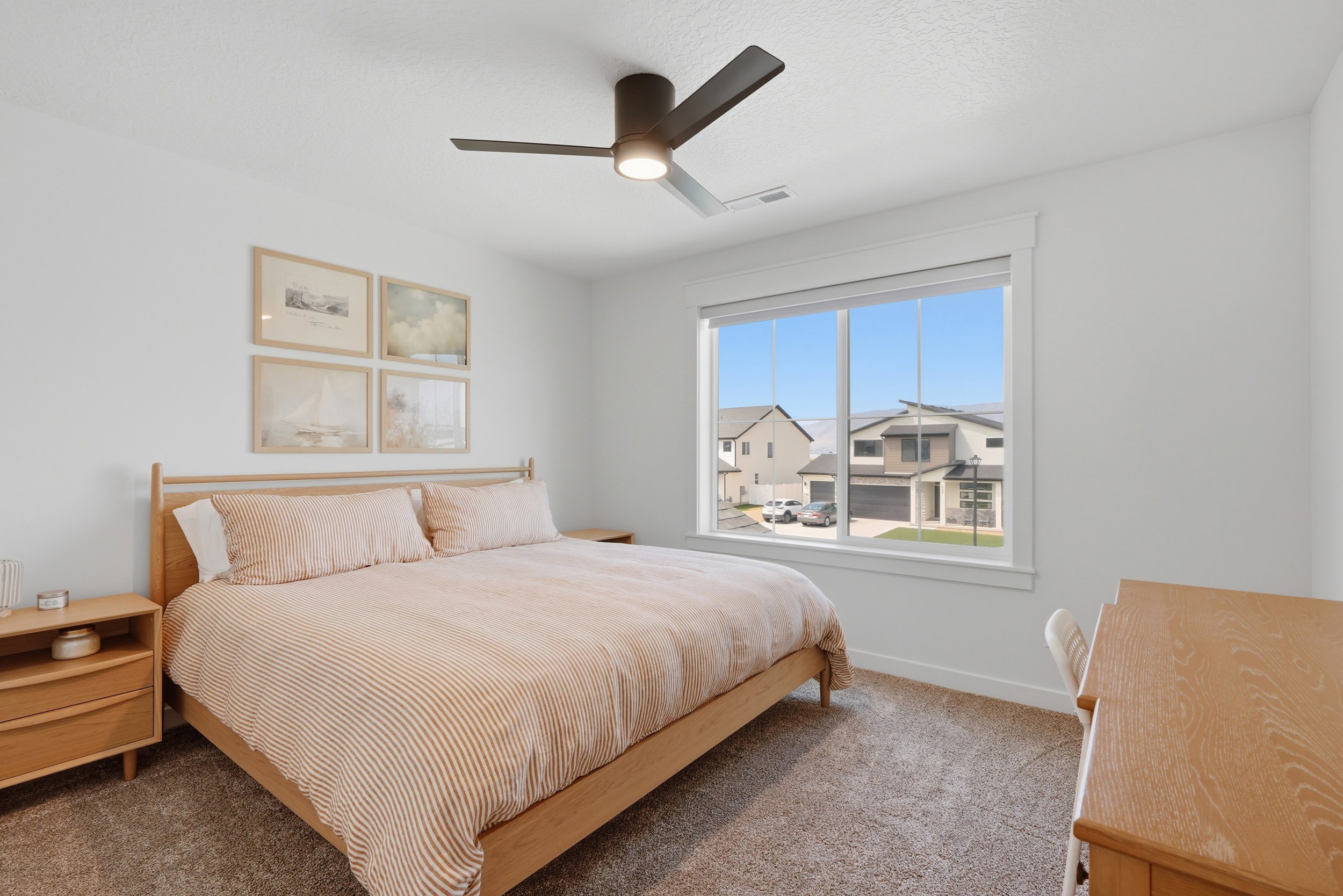 Spacious room featuring a large window, neutral wall tones, and textured carpet flooring