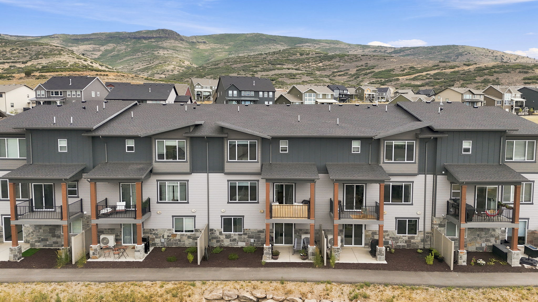 Contemporary townhome community featuring multi-level units with private patios and balconies