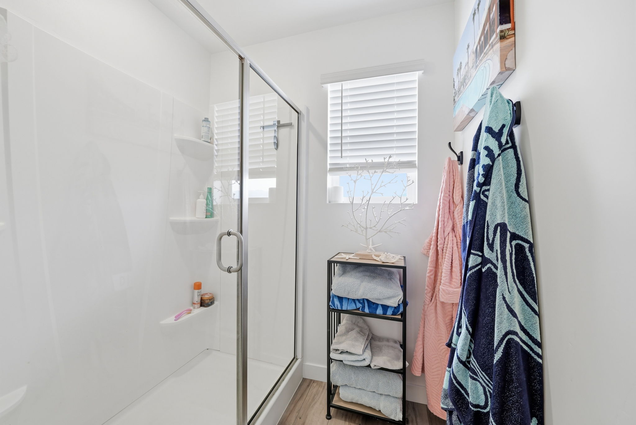 Shower enclosure featuring clear glass door, chrome hardware, and integrated shelving