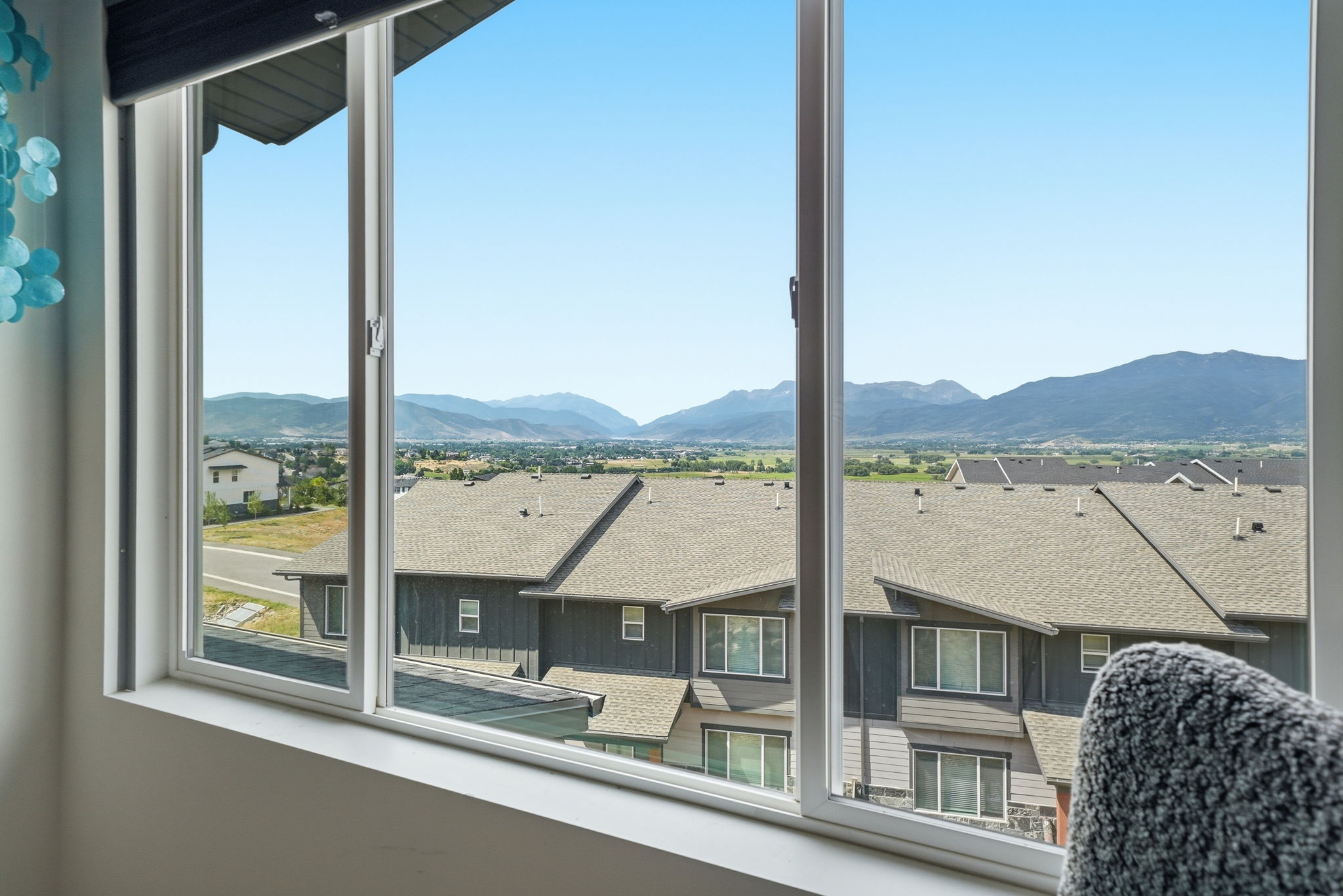 Expansive window framing distant mountain ranges and a scenic valley