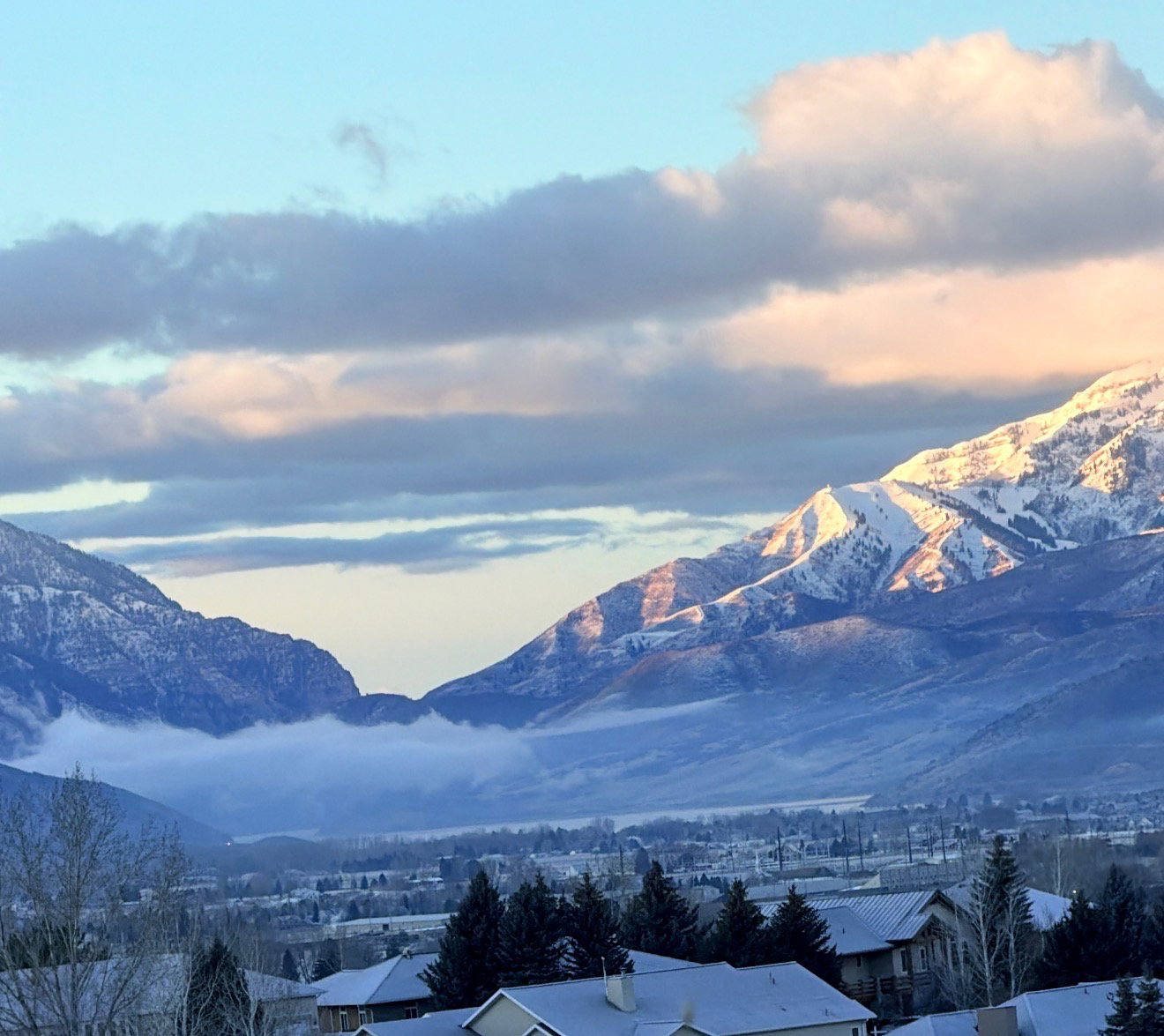 Snow-capped mountain range encompassing a valley with residential structures