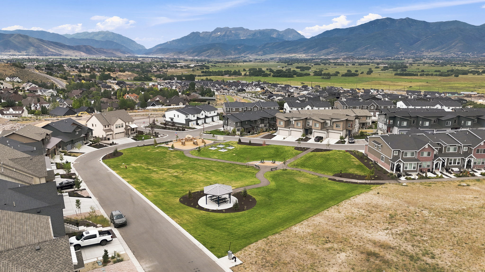 Community green space featuring a paved walking path, gazebo, and playground area