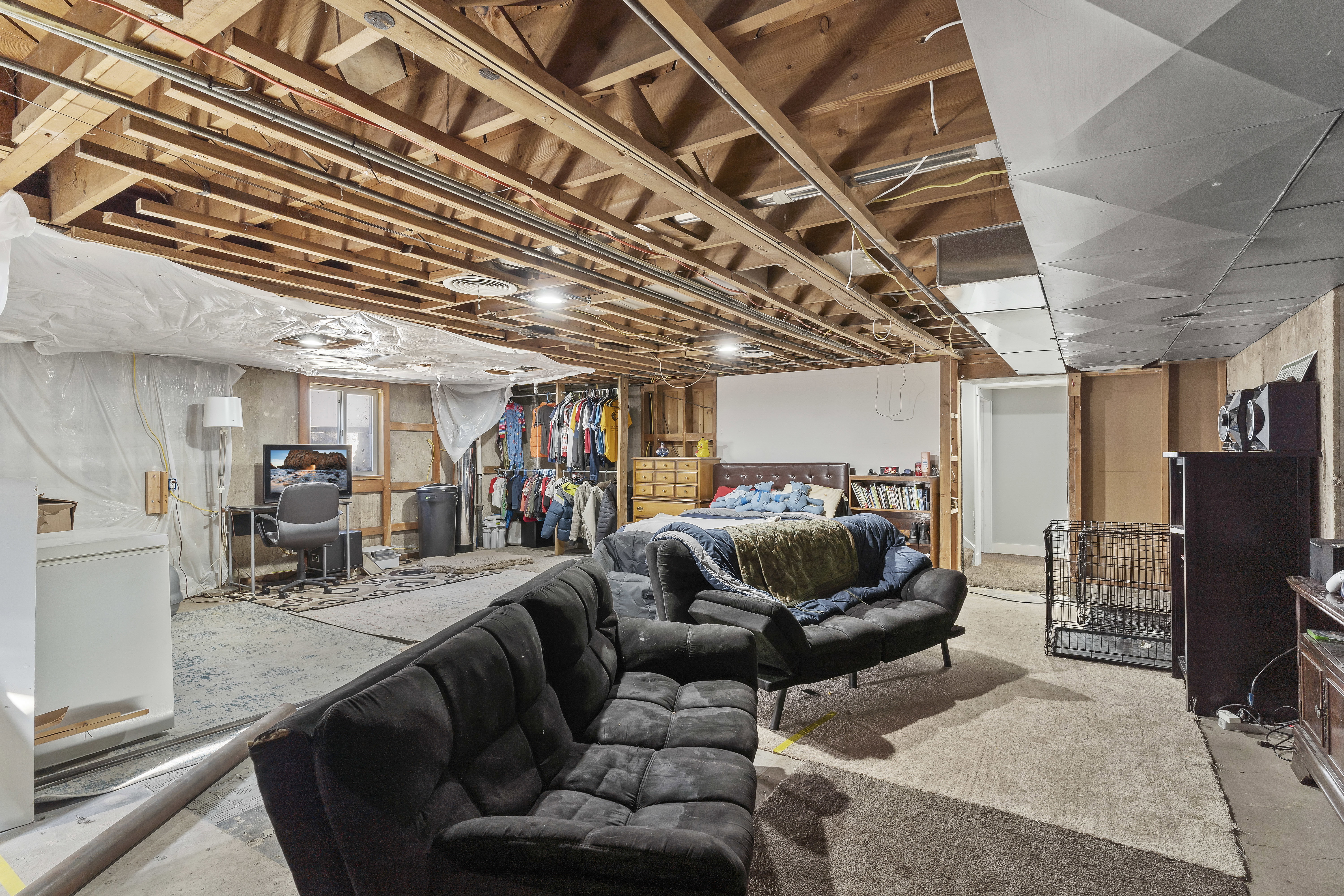 Unfinished basement featuring exposed wood ceiling joists and concrete flooring