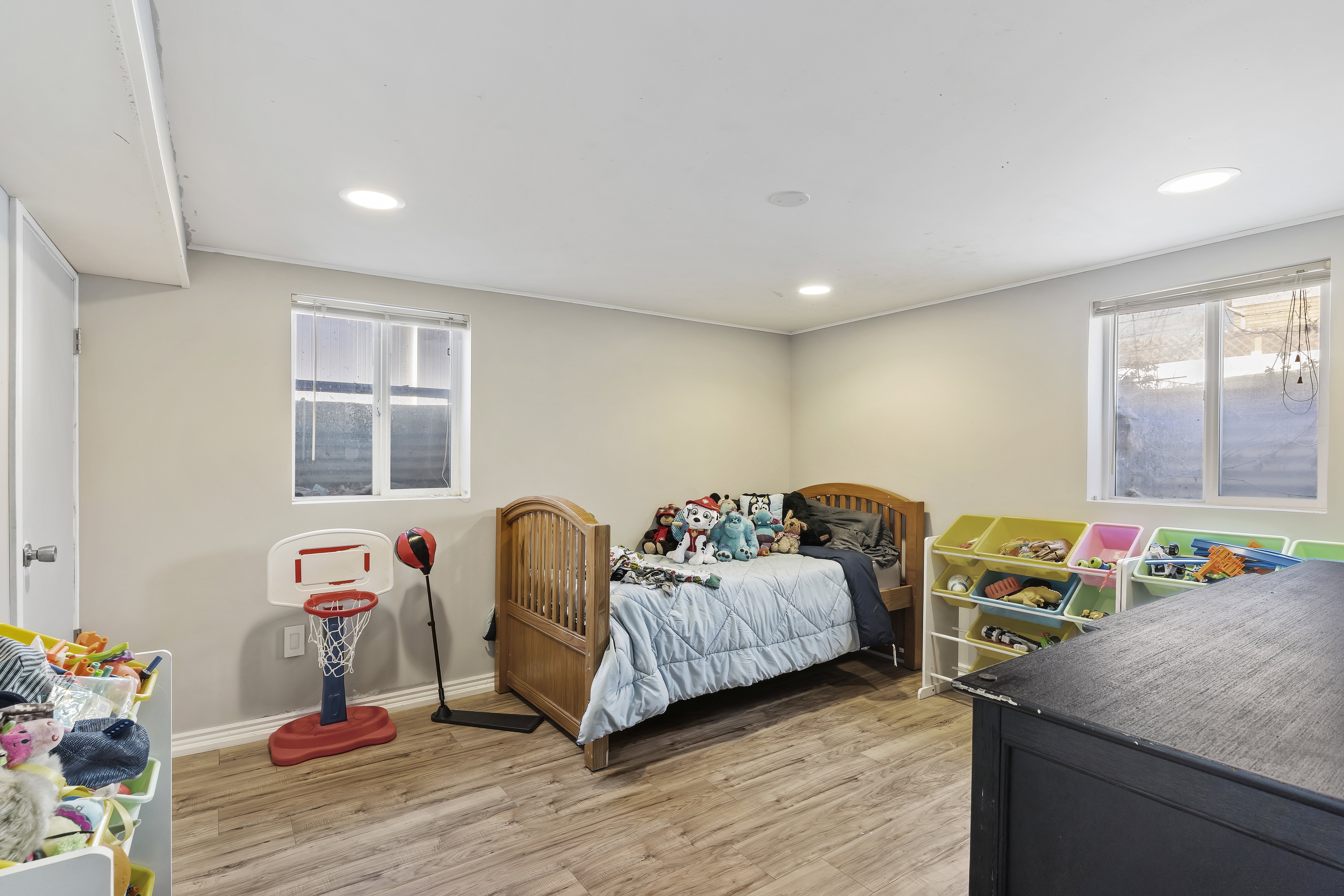 Well-lit room featuring recessed lighting, two windows, wood-finish flooring, and light-toned walls