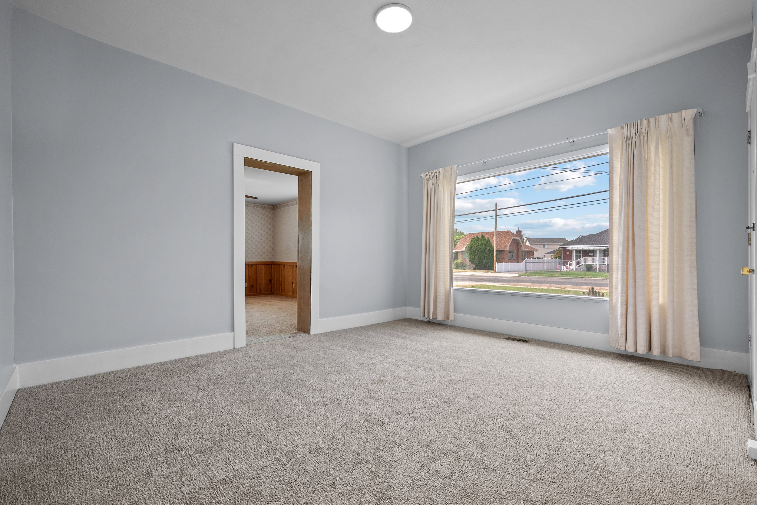 Spacious Great Room featuring new paint and carpet with a large front viewing window.