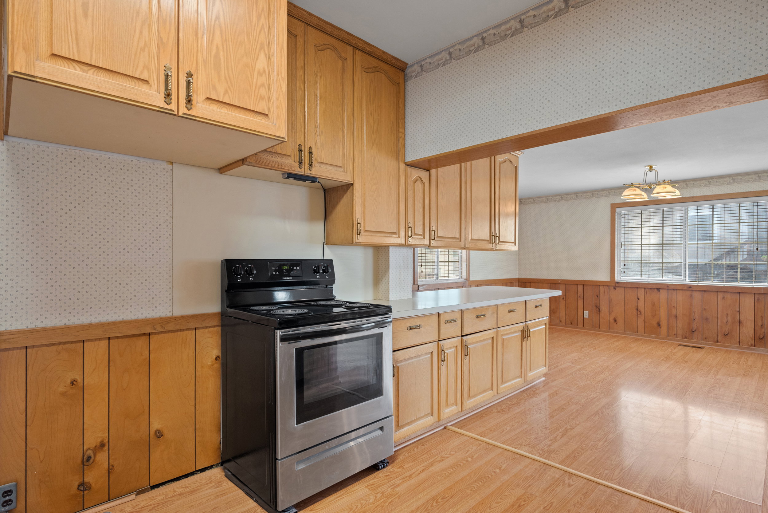 Kitchen featuring wood-finish cabinetry, stainless steel range, and light-colored countertops