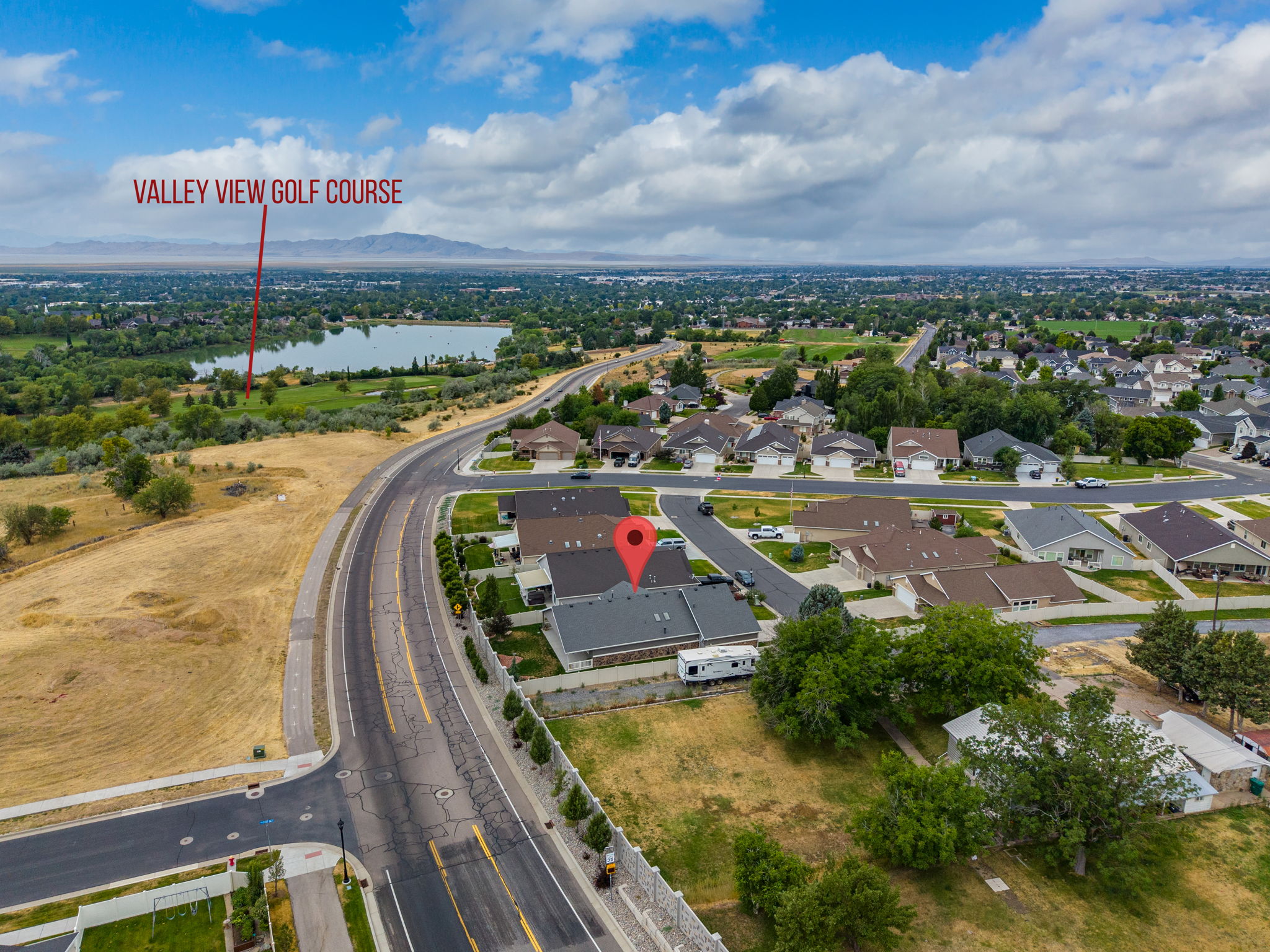 Aerial perspective showcasing the residential neighborhood with a large body of water and distant mountains