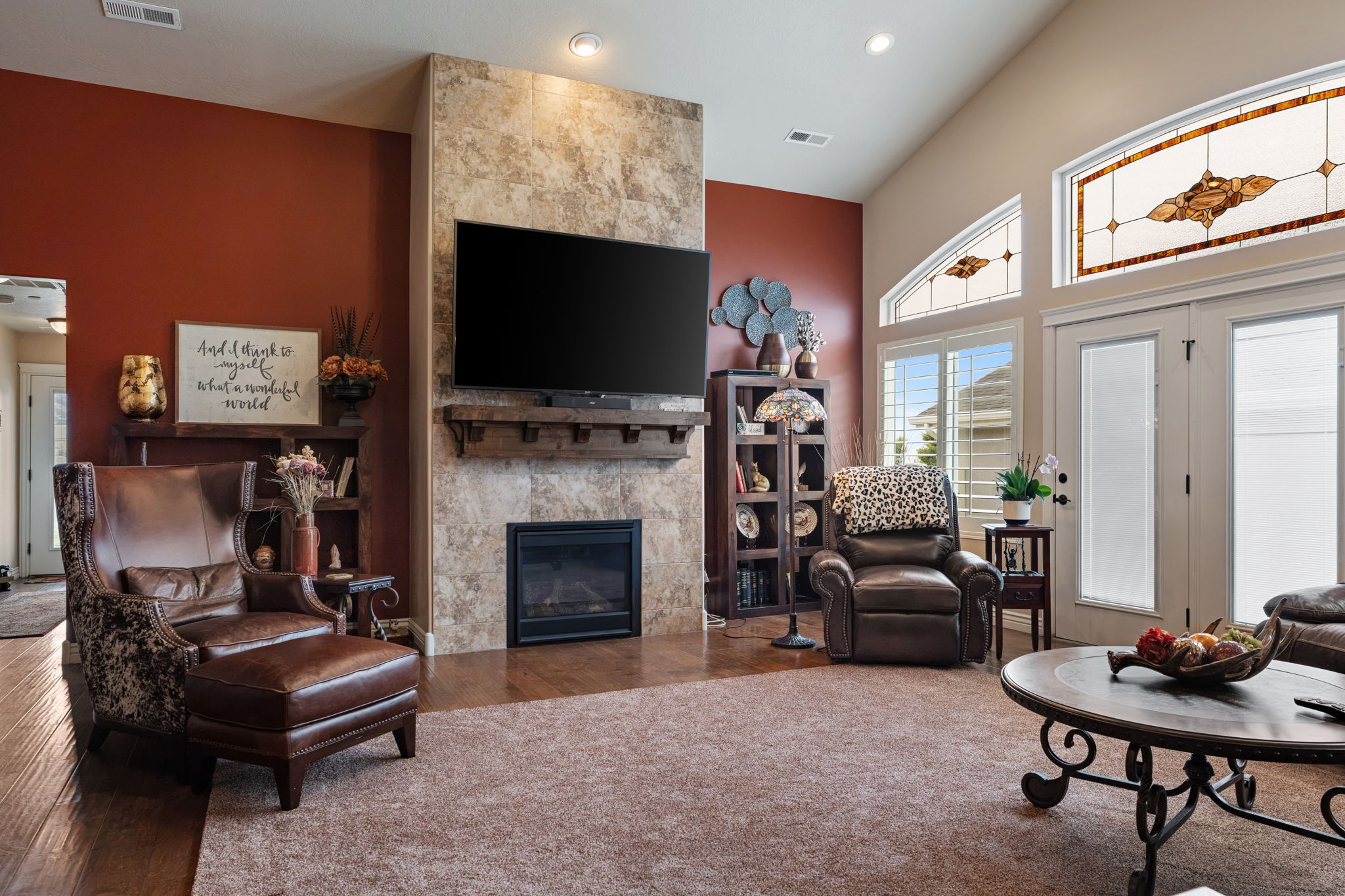 Vaulted ceilings accentuating a stone-clad fireplace with a wood mantel