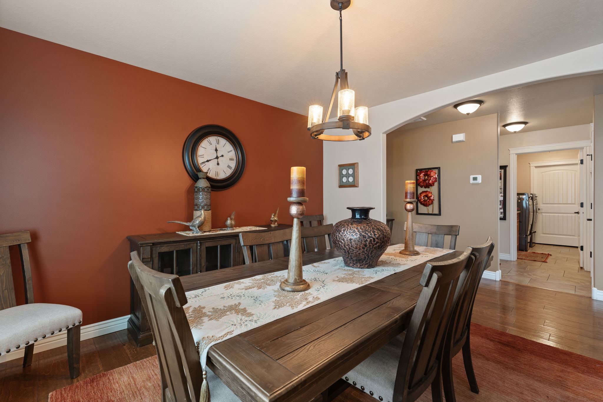 Dining space featuring wood-finish flooring, a contemporary chandelier, and an arched entryway