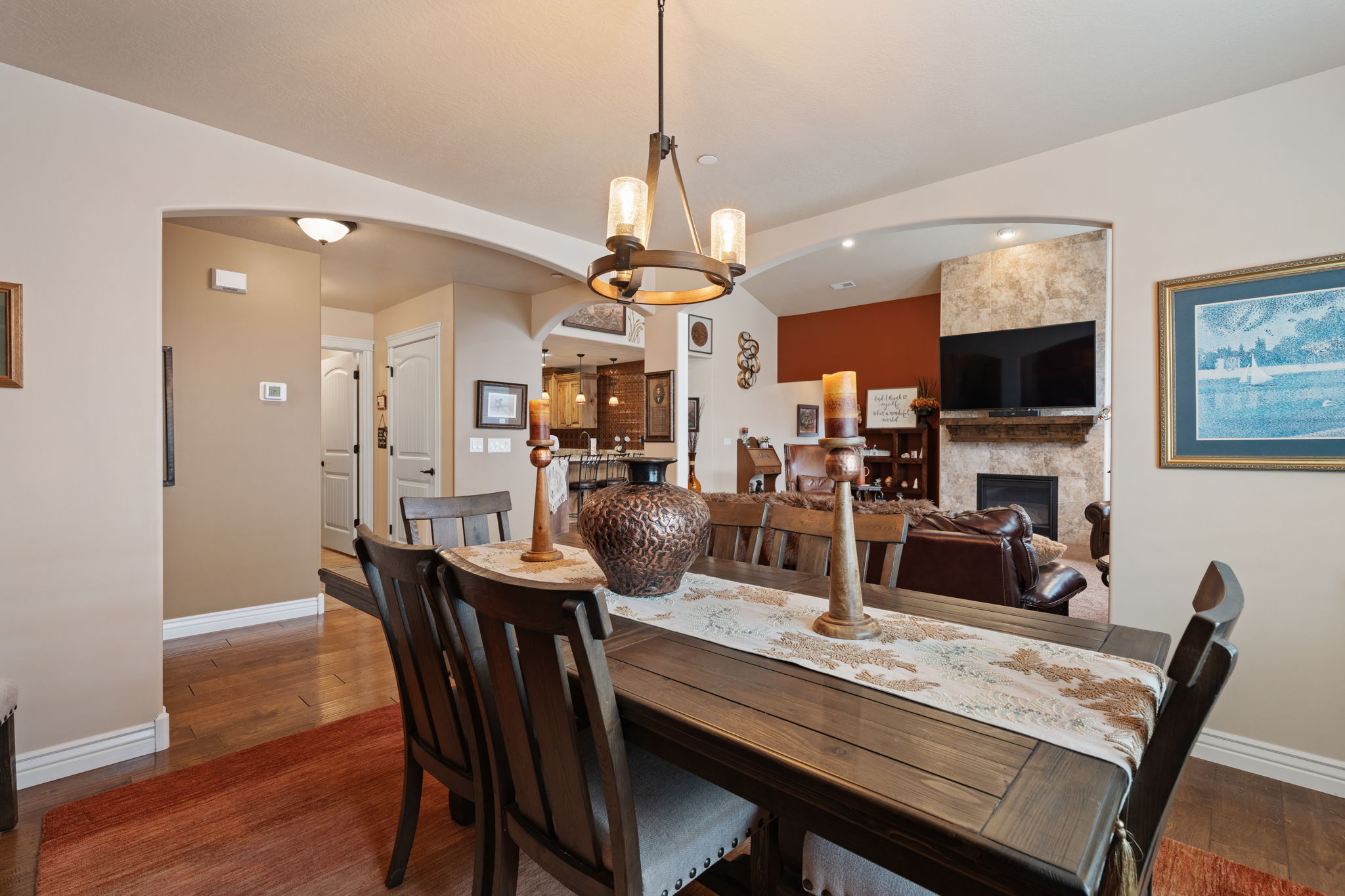 Dining area featuring a wood-finish table, upholstered chairs, and an overhead chandelier with clear glass shades
