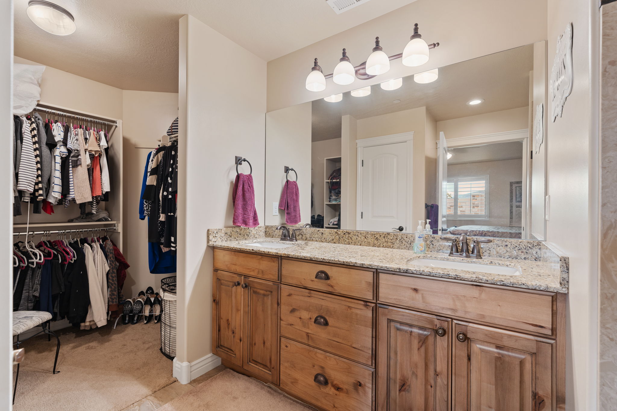 Double vanity featuring wood cabinetry, granite countertops, and two undermount sinks