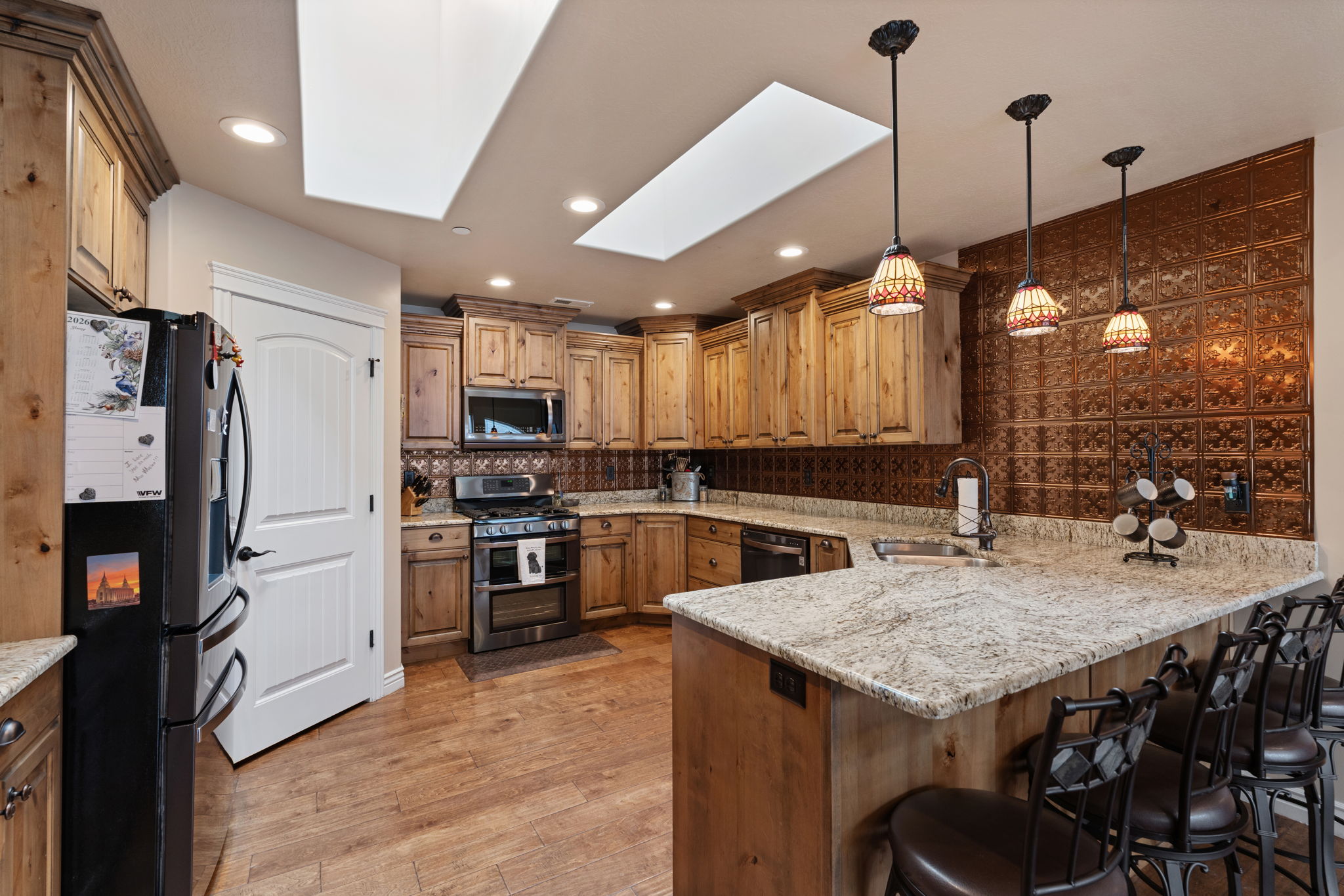 Kitchen featuring wood-finish flooring, light wood cabinetry, and a central island with a light-toned countertop