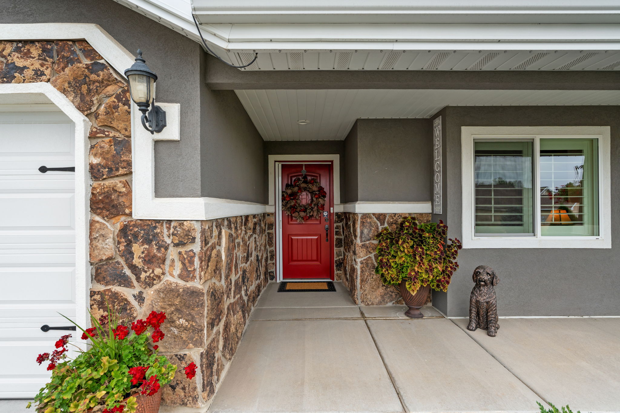 Stucco and stone facade featuring a vibrant red entry door