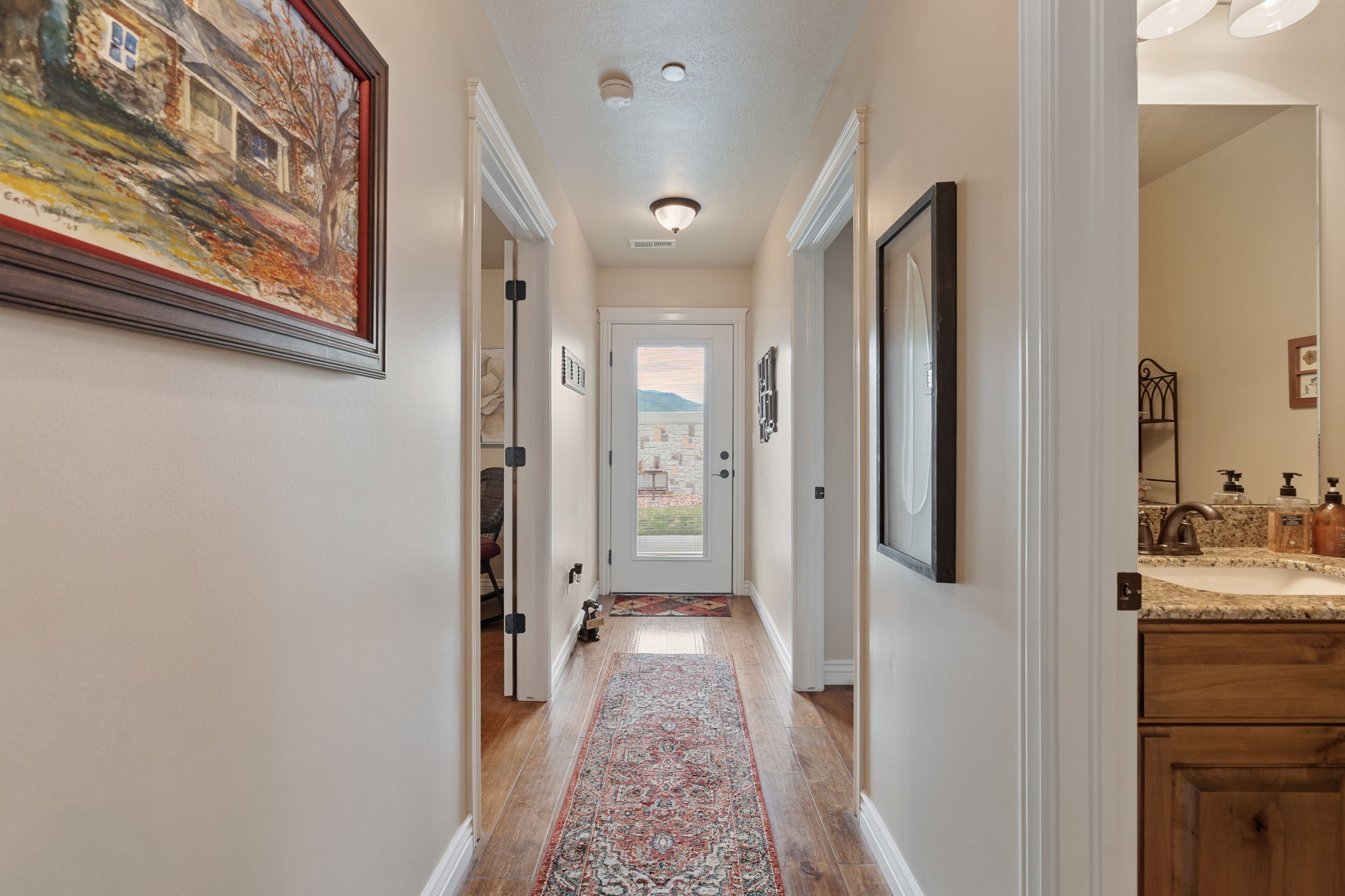 Hallway featuring wood-finish flooring and light-toned walls
