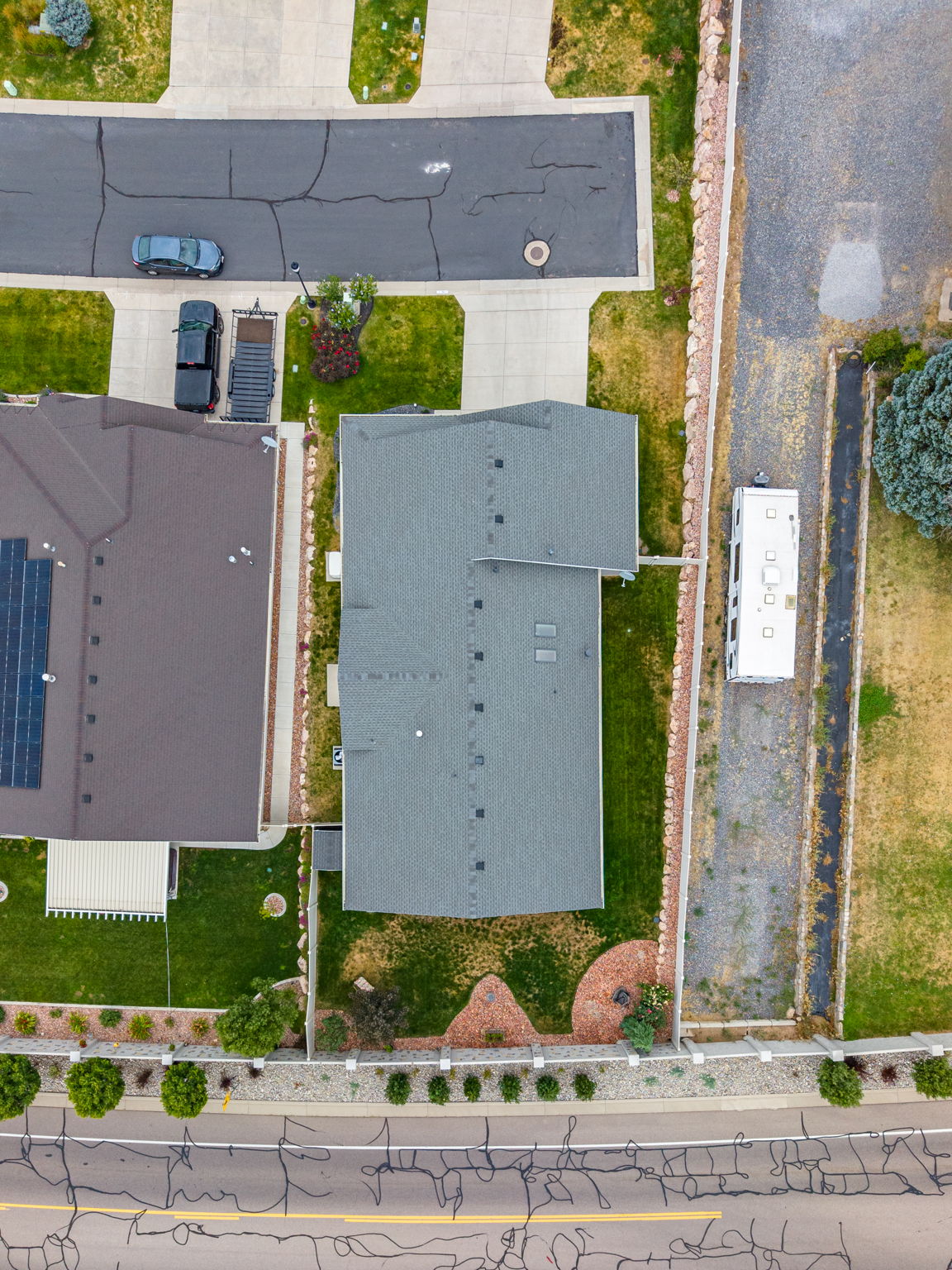Two-story residence with a gray shingle roof and a concrete driveway