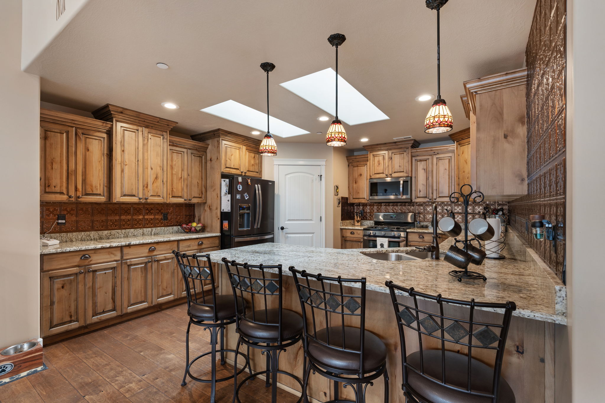 Spacious kitchen featuring wood-finish cabinetry, granite countertops, and wood-finish flooring