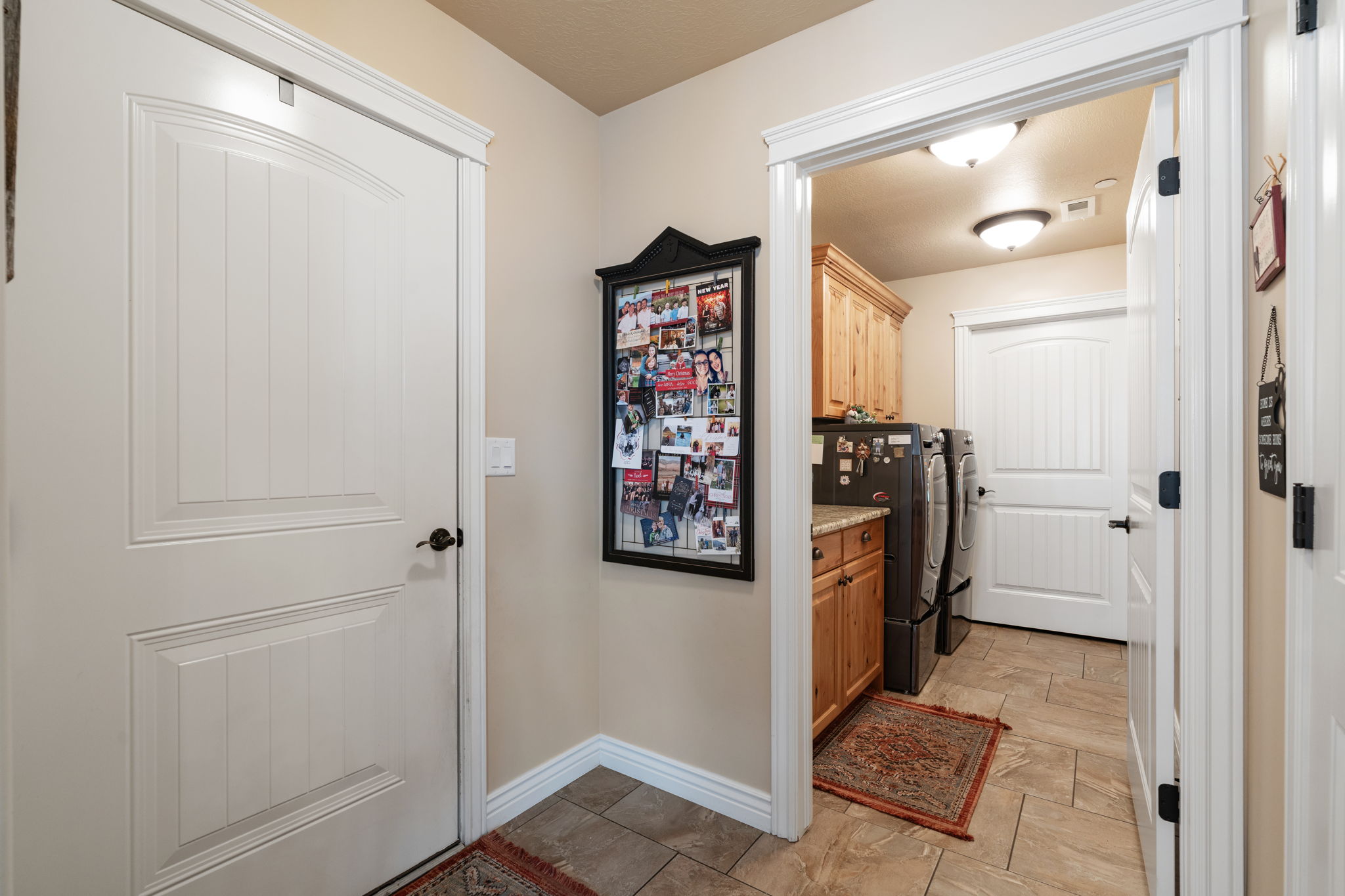 Utility area featuring wood cabinetry, stone-finish countertops, and tiled flooring
