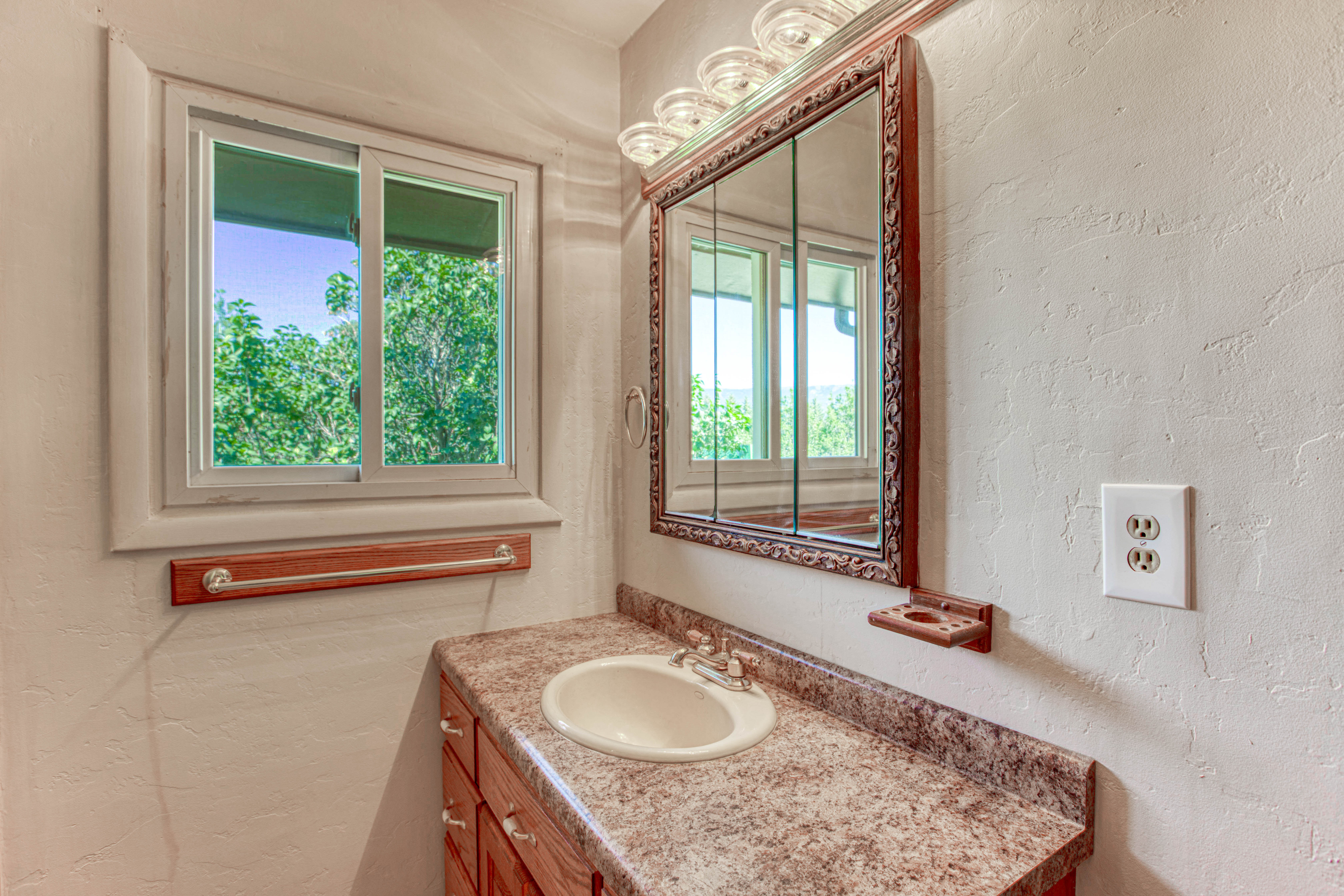Bathroom vanity featuring an integrated sink, laminate countertop, and wood-finish cabinetry