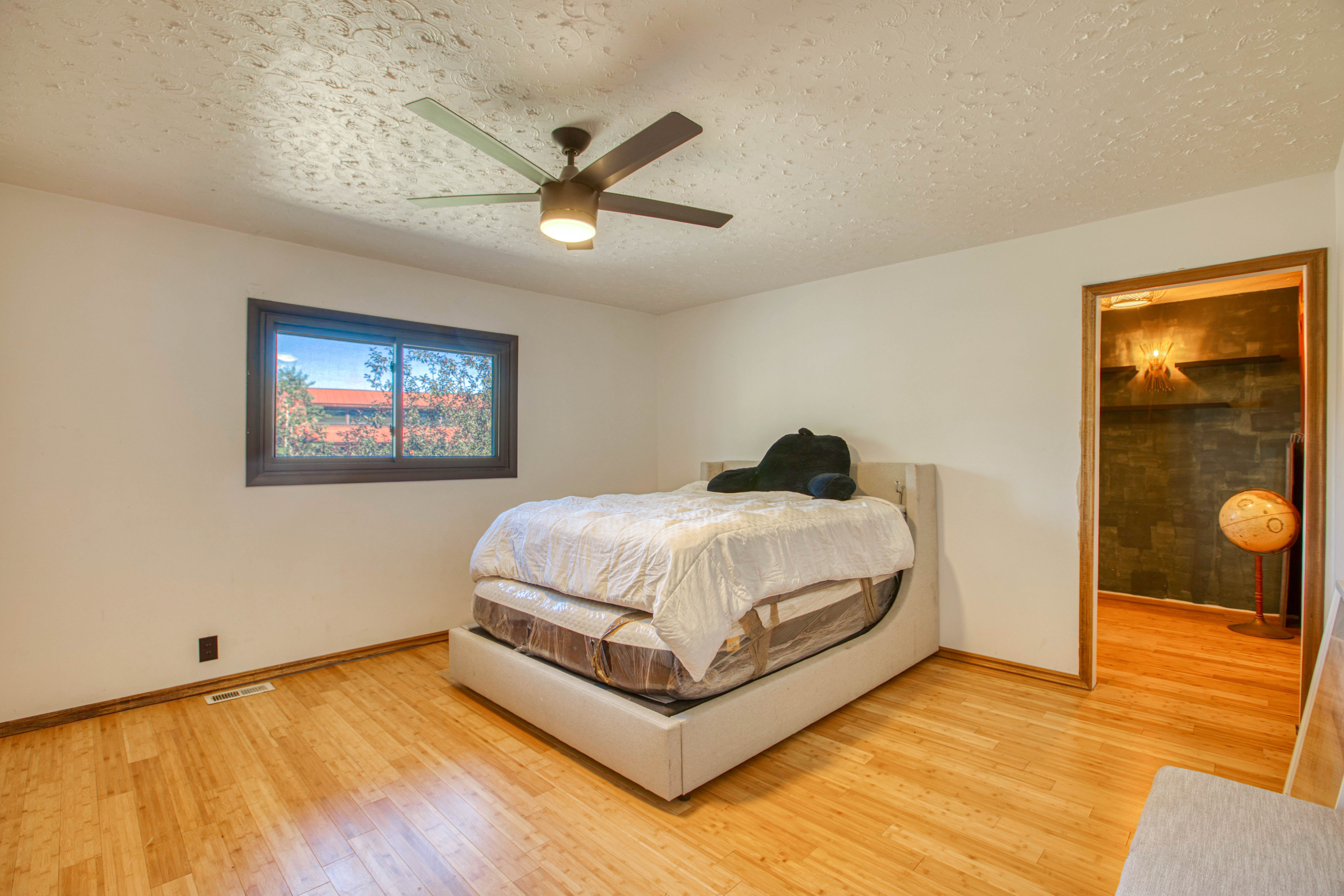 Wood-finish flooring throughout, complemented by a ceiling fan with integrated lighting