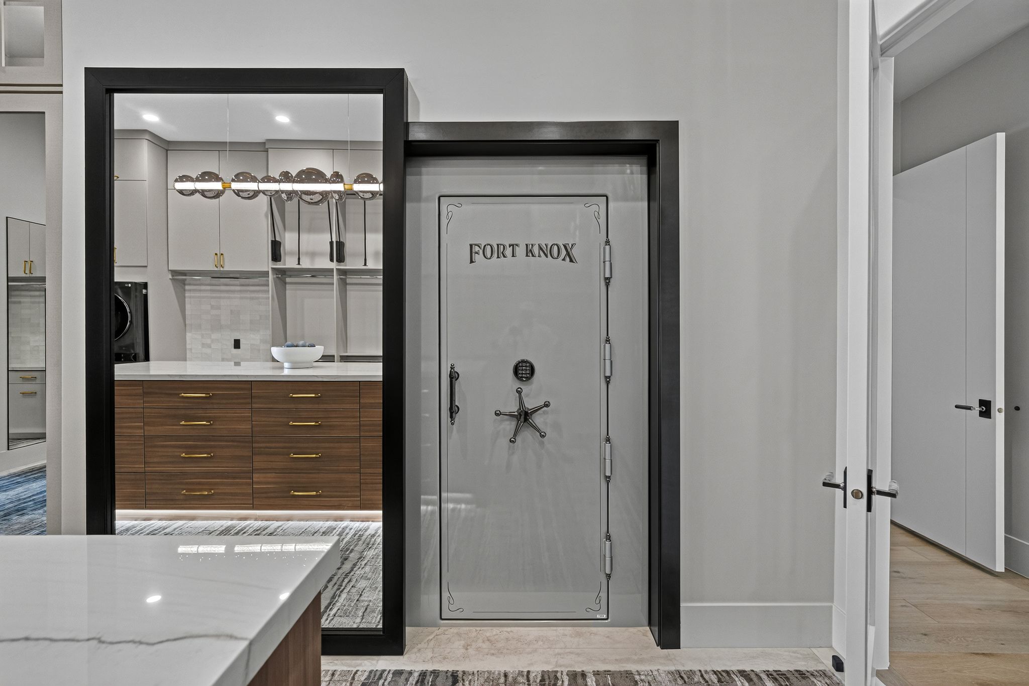 Custom-designed safe door with a star-shaped handle, set within a black frame, beside an open doorway