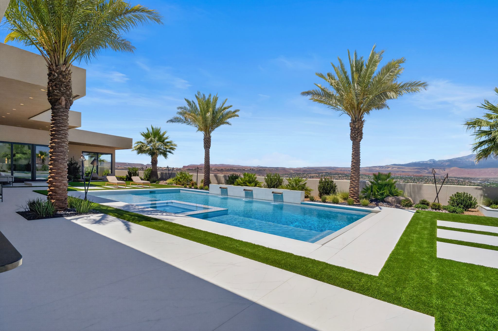 Expansive outdoor living area featuring a rectangular pool and integrated spa