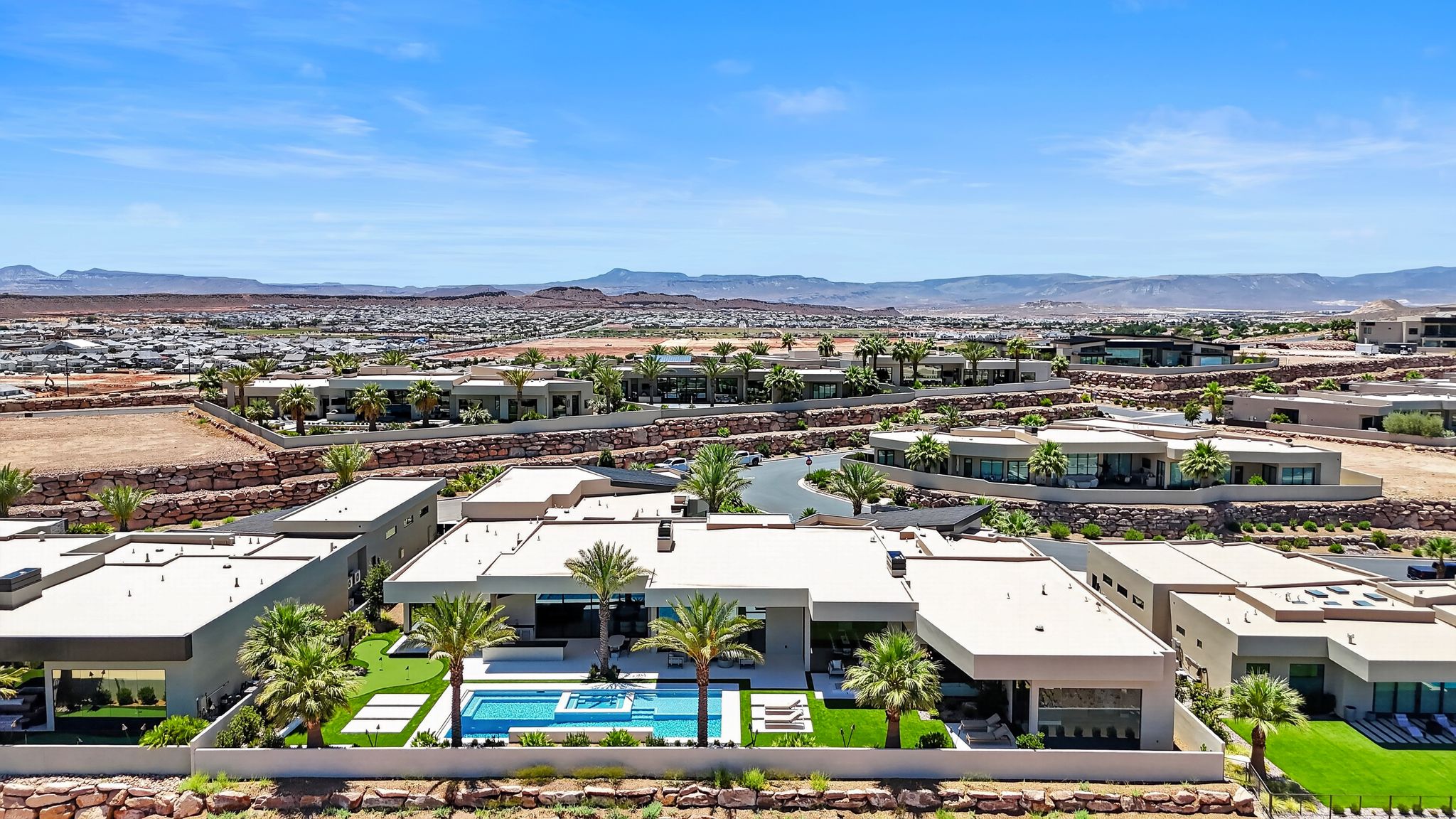 Modern single-story residence featuring a rectangular swimming pool, integrated spa, and manicured artificial turf