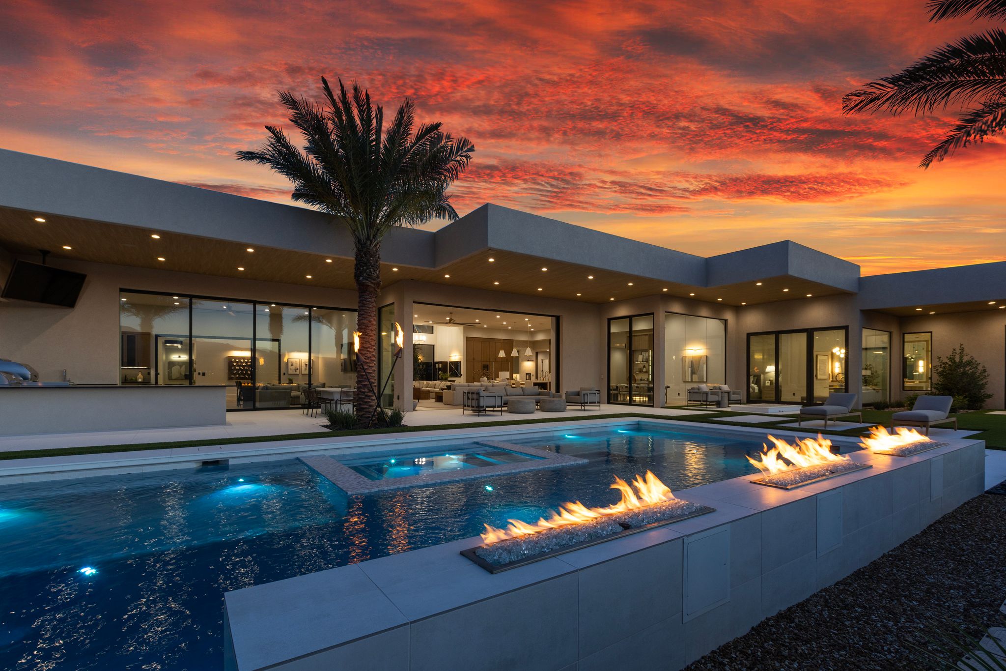 Backyard oasis with a contemporary pool, integrated spa, and linear fire features