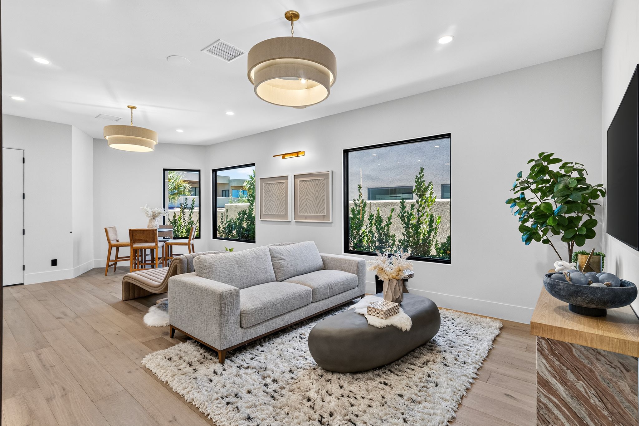 Open-concept living space with light wood-finish flooring, white walls, and recessed lighting