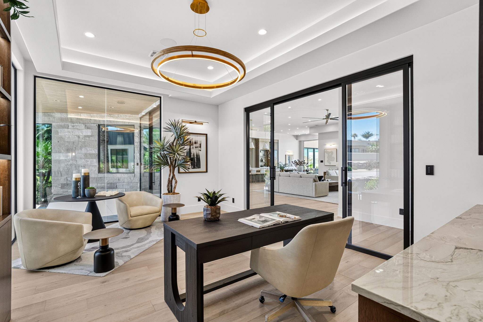 Dedicated office space featuring light wood-finish flooring, a contemporary chandelier, recessed ceiling lighting, and large glass panel doors