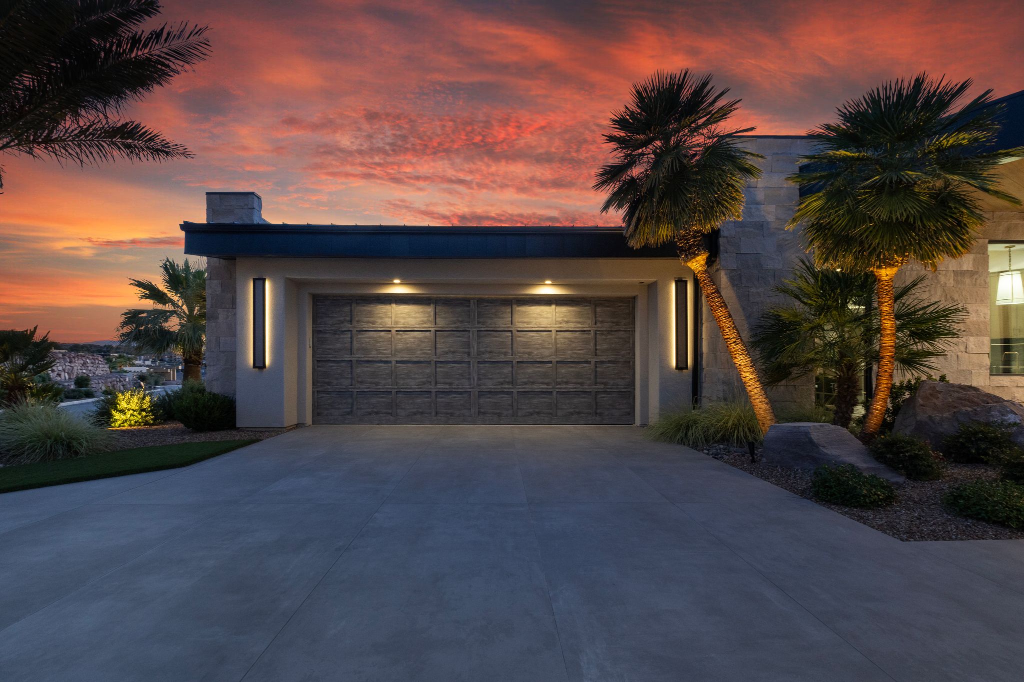 Contemporary residence with an expansive concrete driveway and a textured garage door