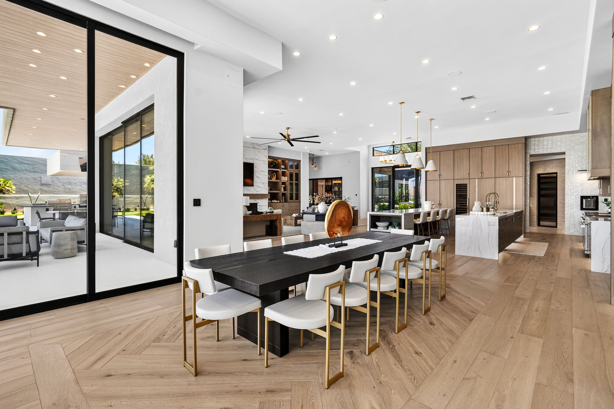 Expansive open-concept interior featuring light wood-finish flooring in a herringbone pattern