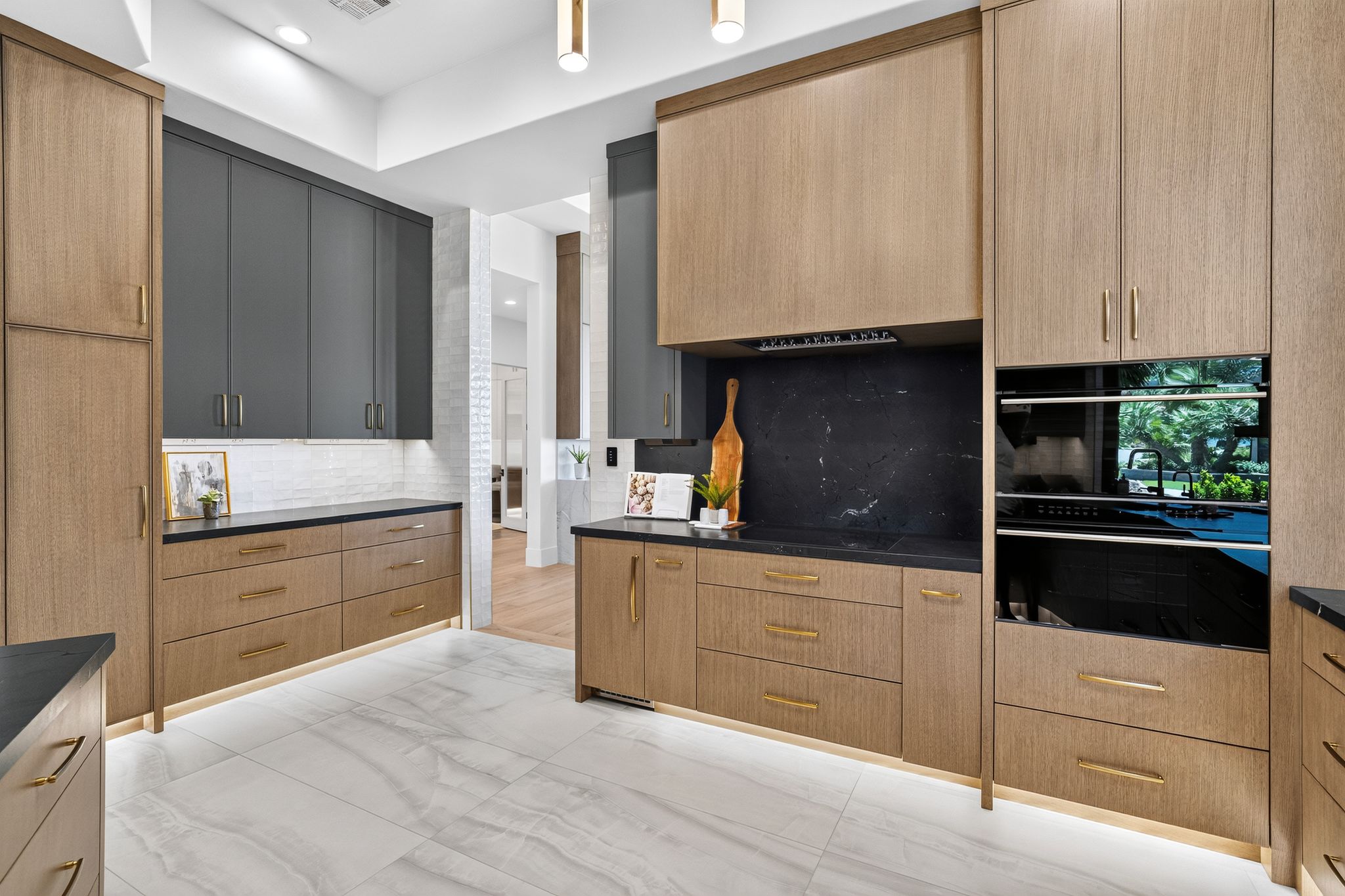 Modern kitchen featuring a two-toned cabinetry design with integrated double ovens