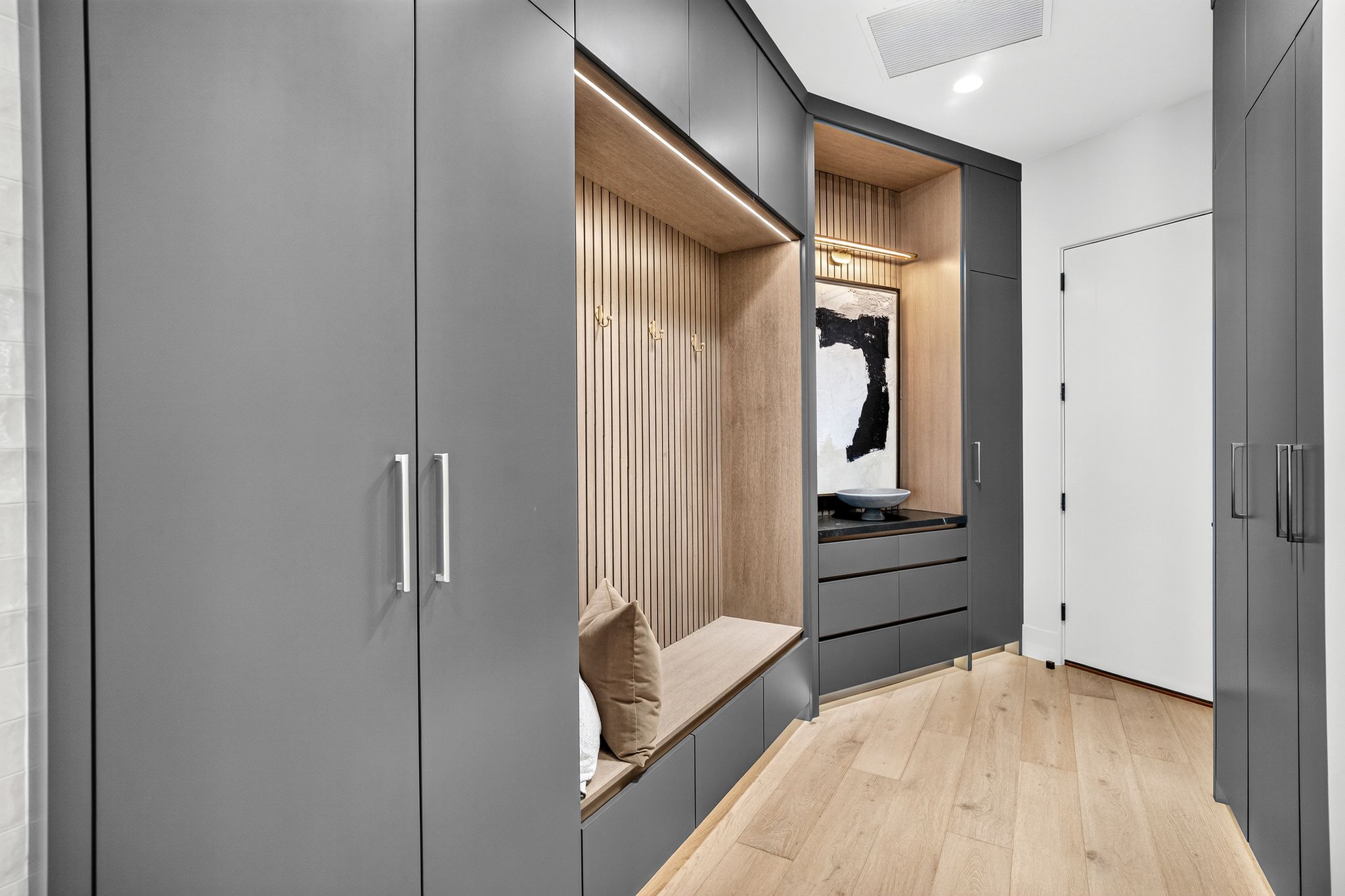 Custom built-in cabinetry in a matte gray finish with integrated storage and a seating bench