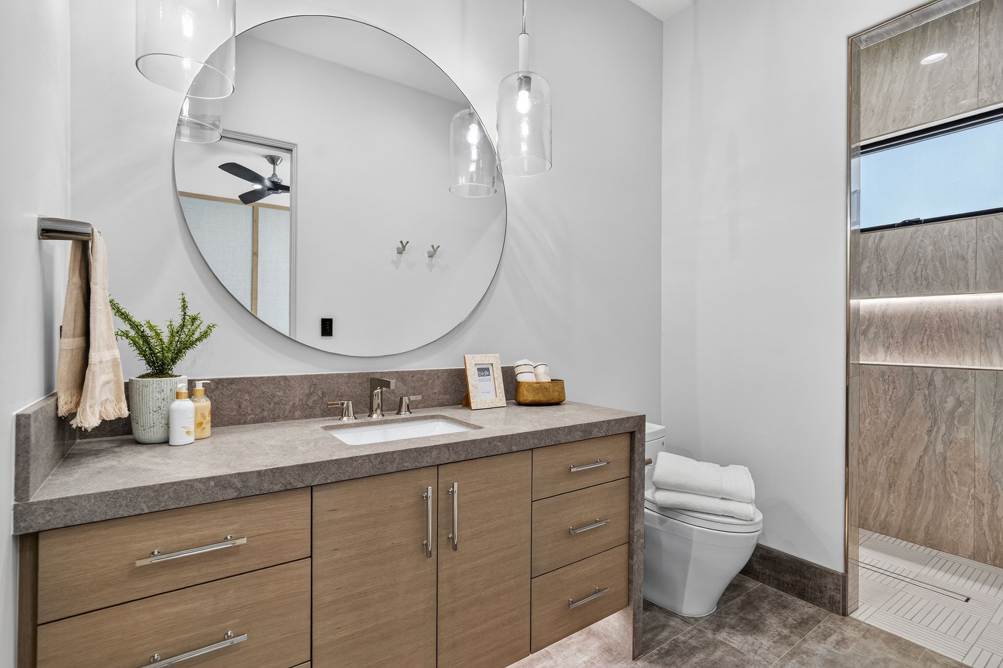 Contemporary bathroom featuring a floating wood-finish vanity with an integrated rectangular sink